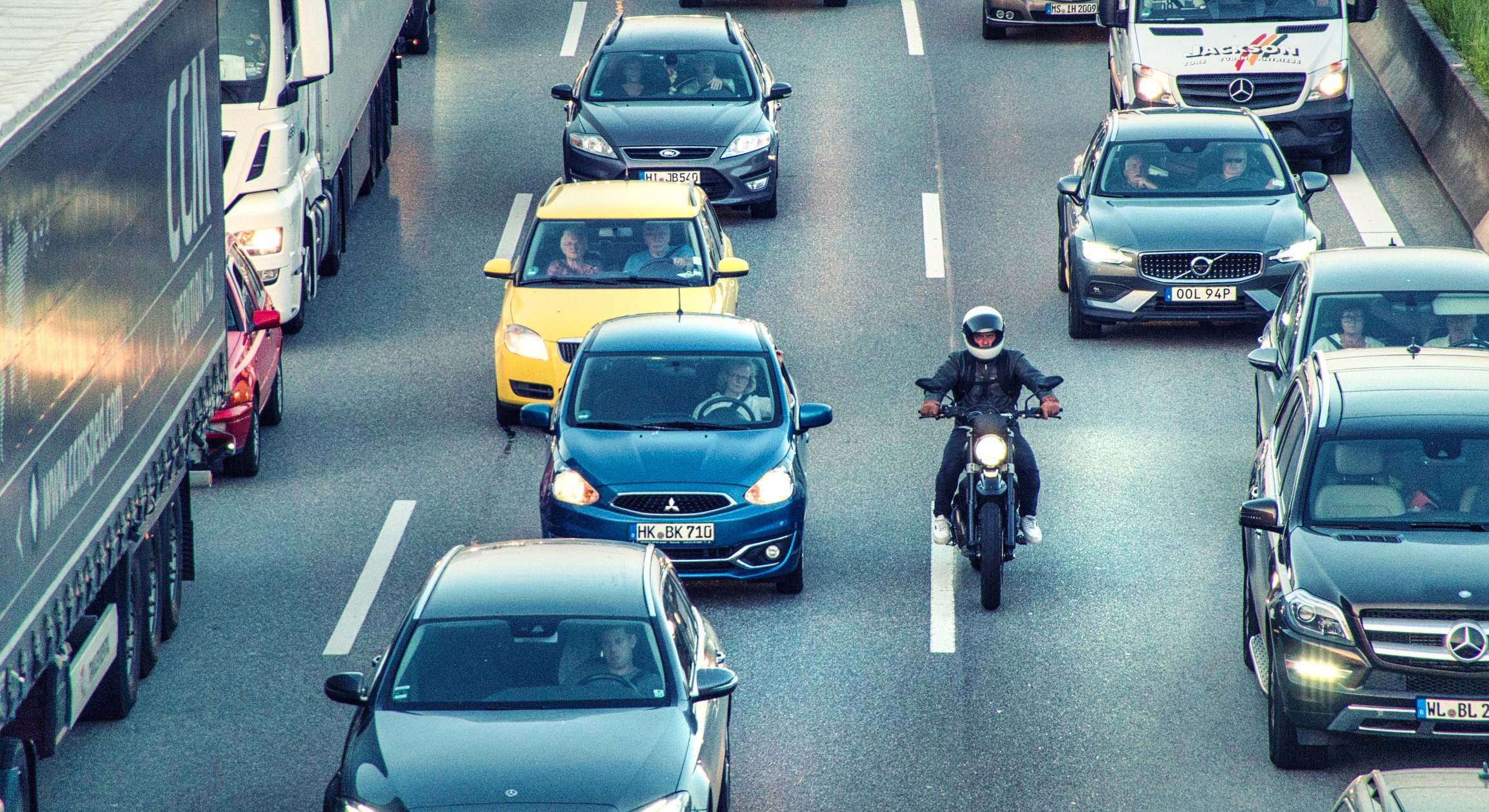 Una moto adelanta a los coches entre carriles