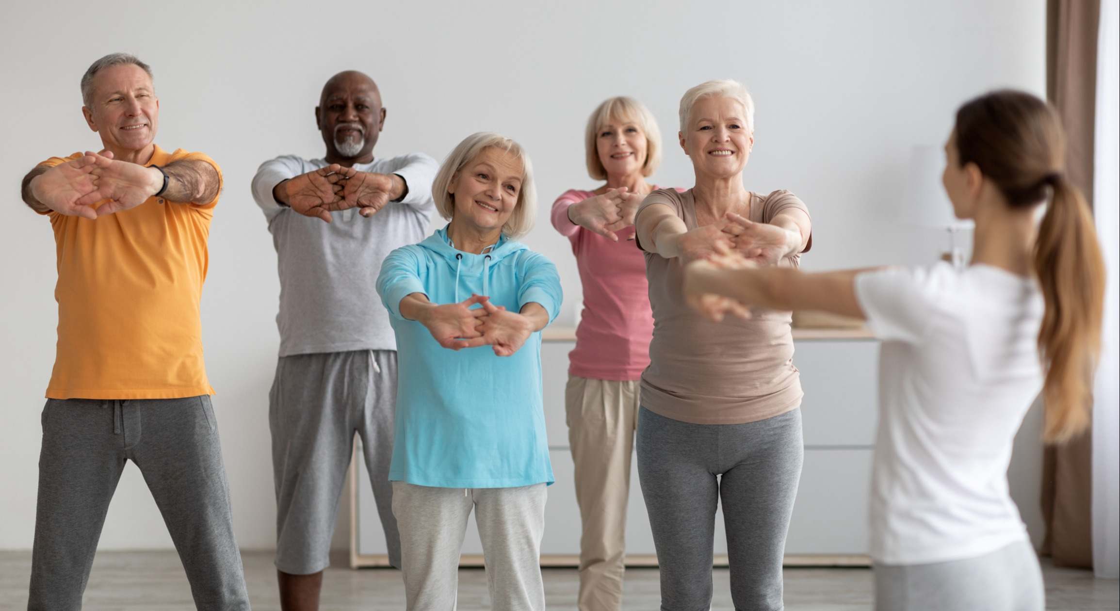 Personas mayores en una clase de fitness junto a una instructora