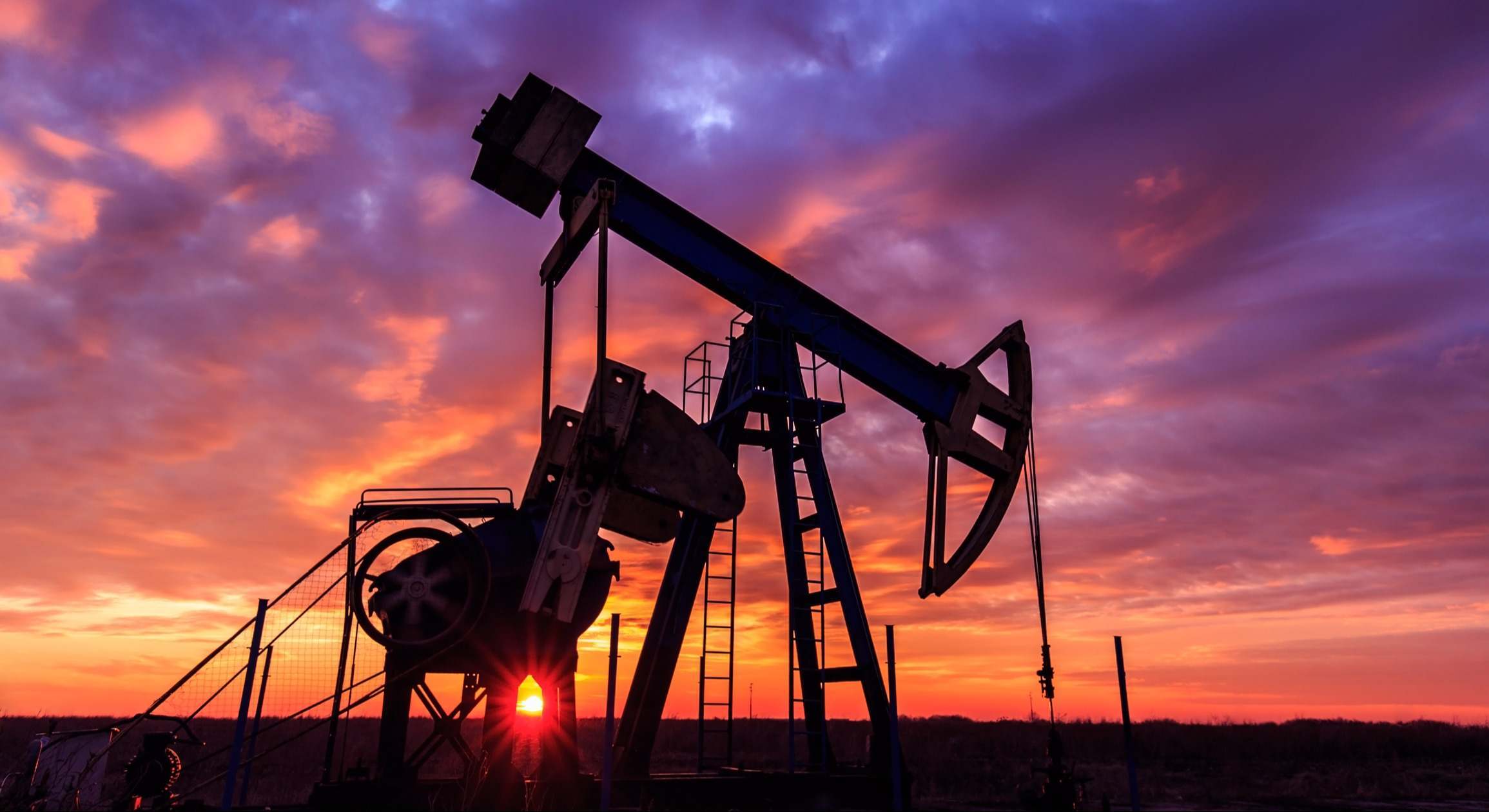 Pozos de petróleo con atardecer detrás