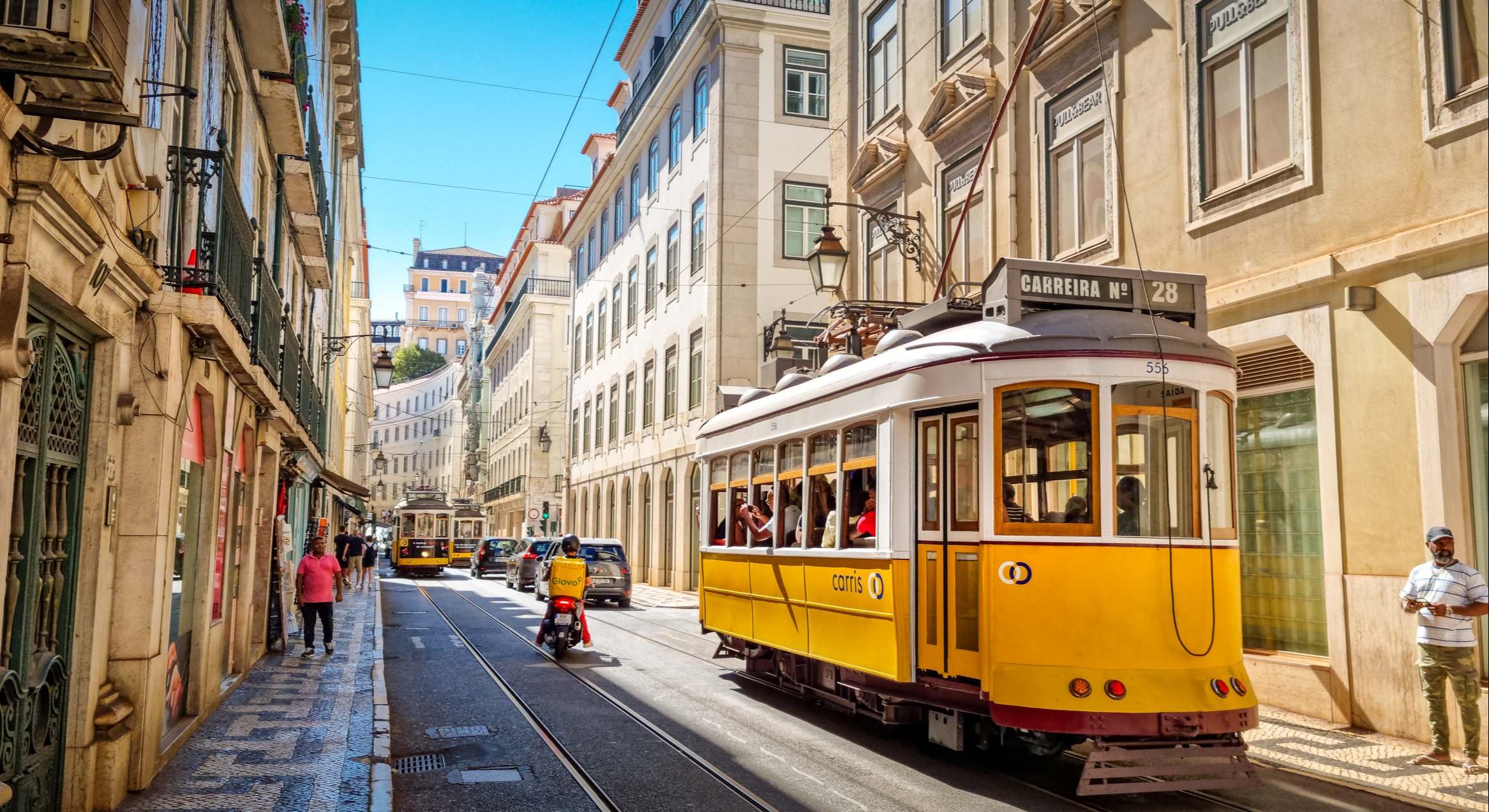 Personas caminando por la línea de tranvía en el centro de Lisboa, Portugal