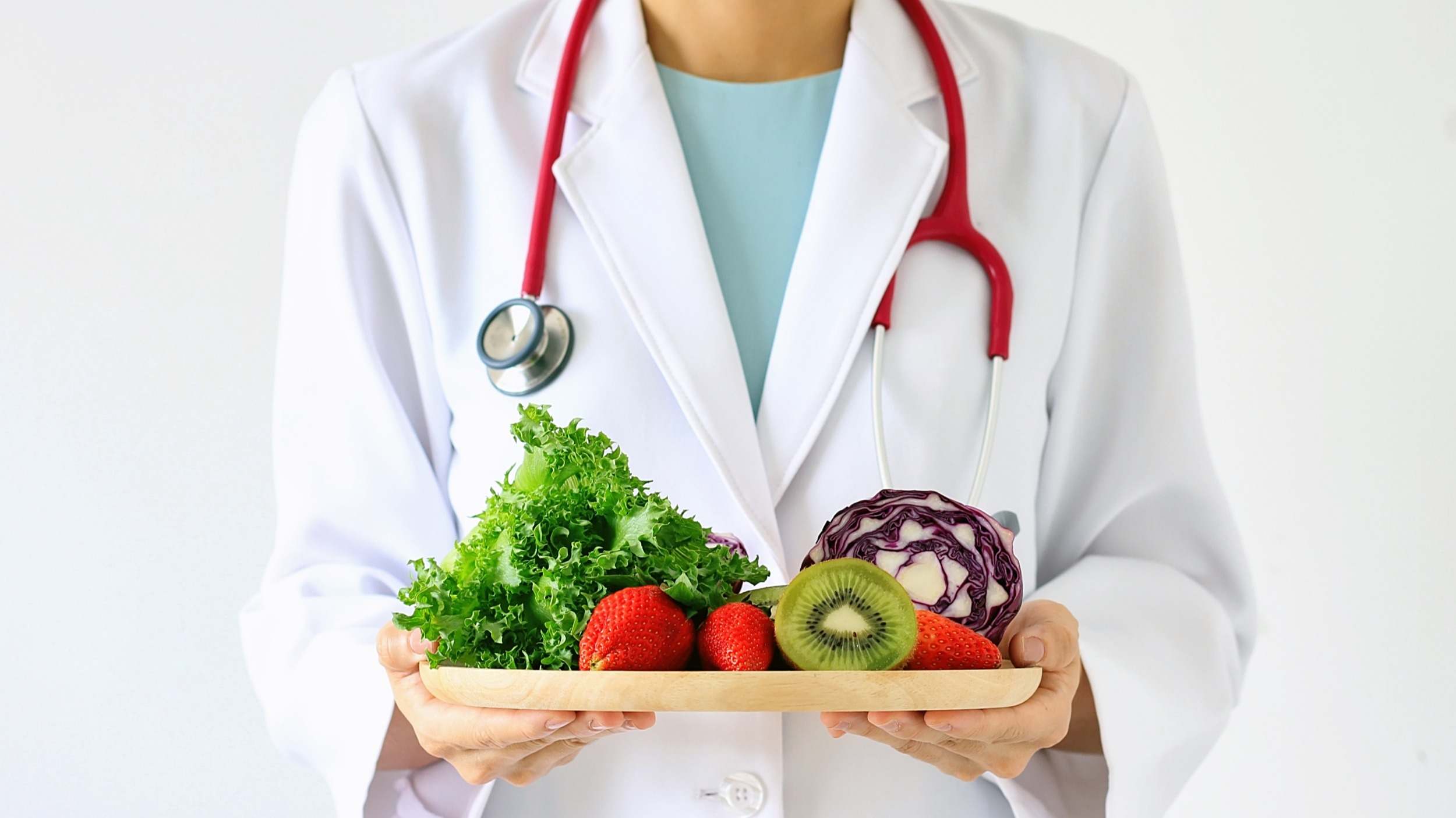 Médico sosteniendo fruta fresca y vegetales dieta saludable