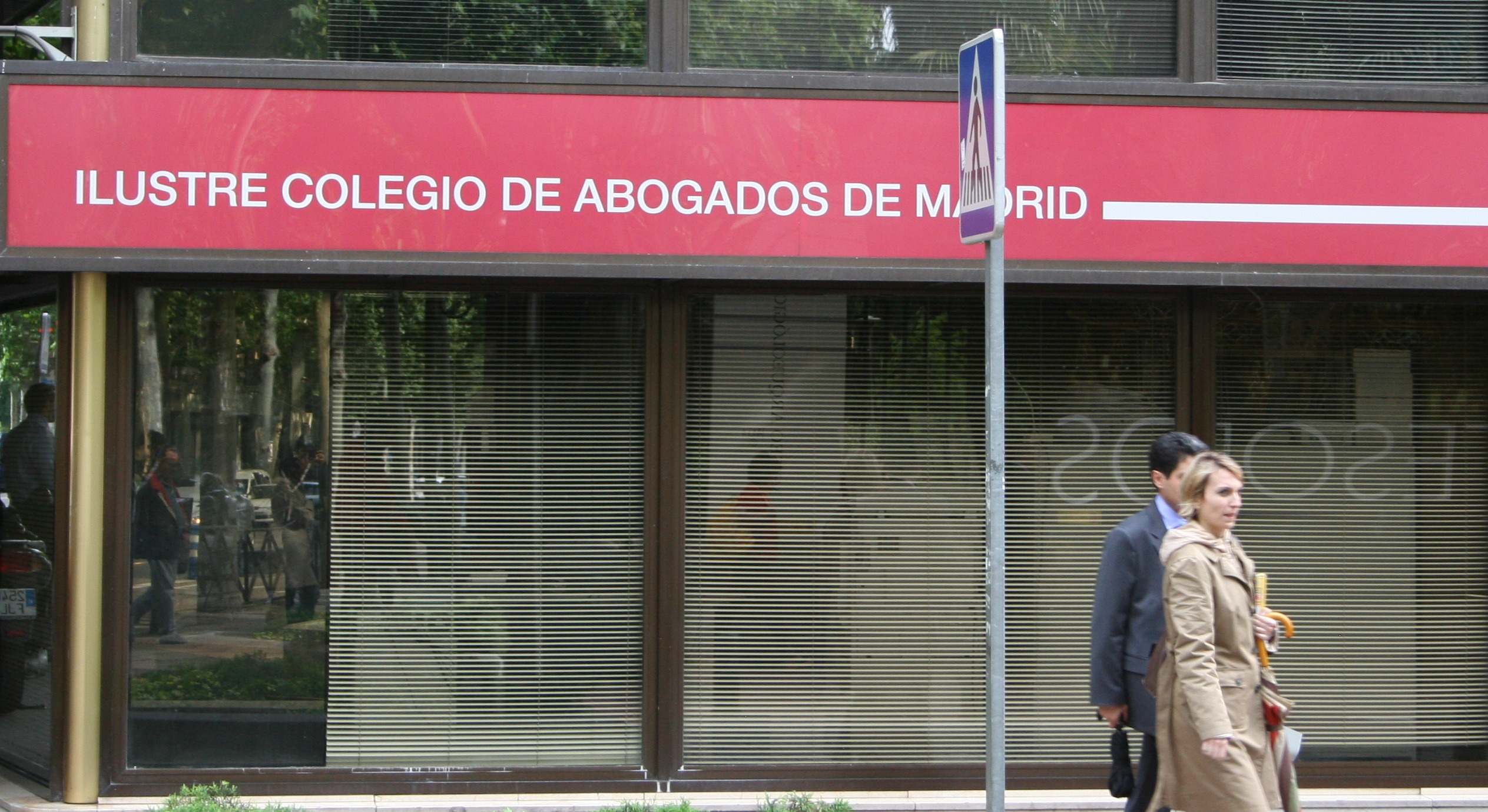 Dos personas caminan por delante del Ilustre colegio de Abogados de Madrid