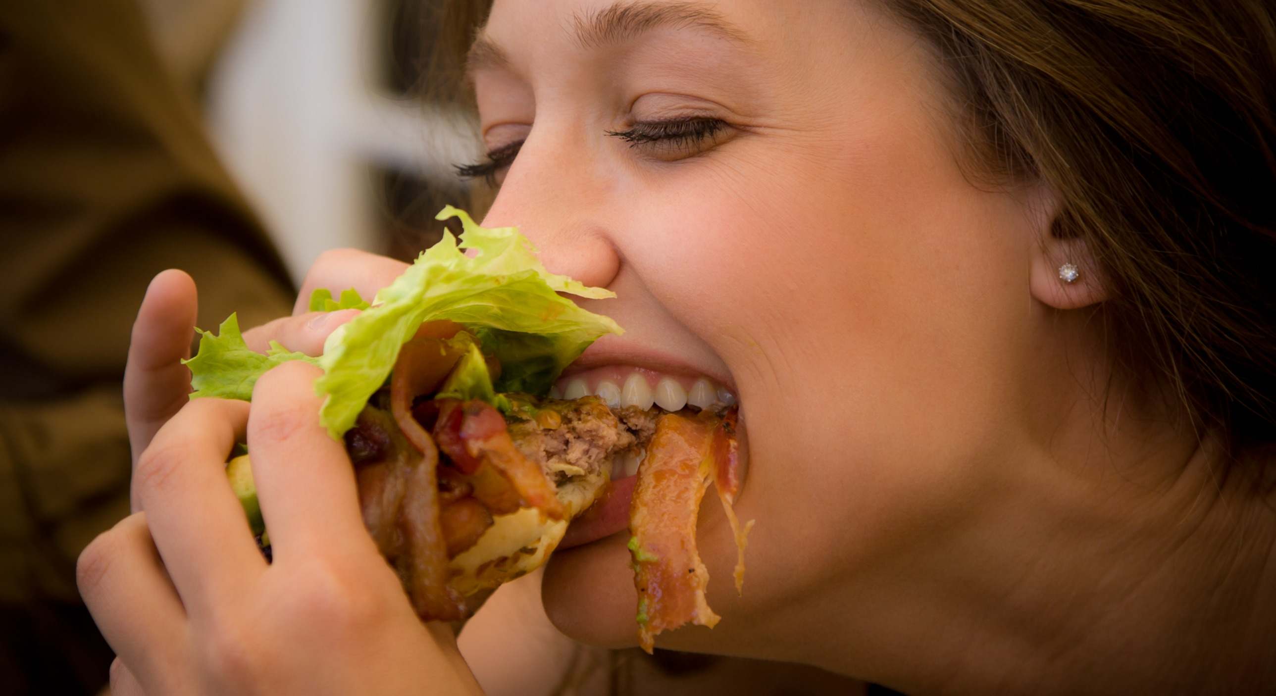 Mujer masticando una hamburguesa