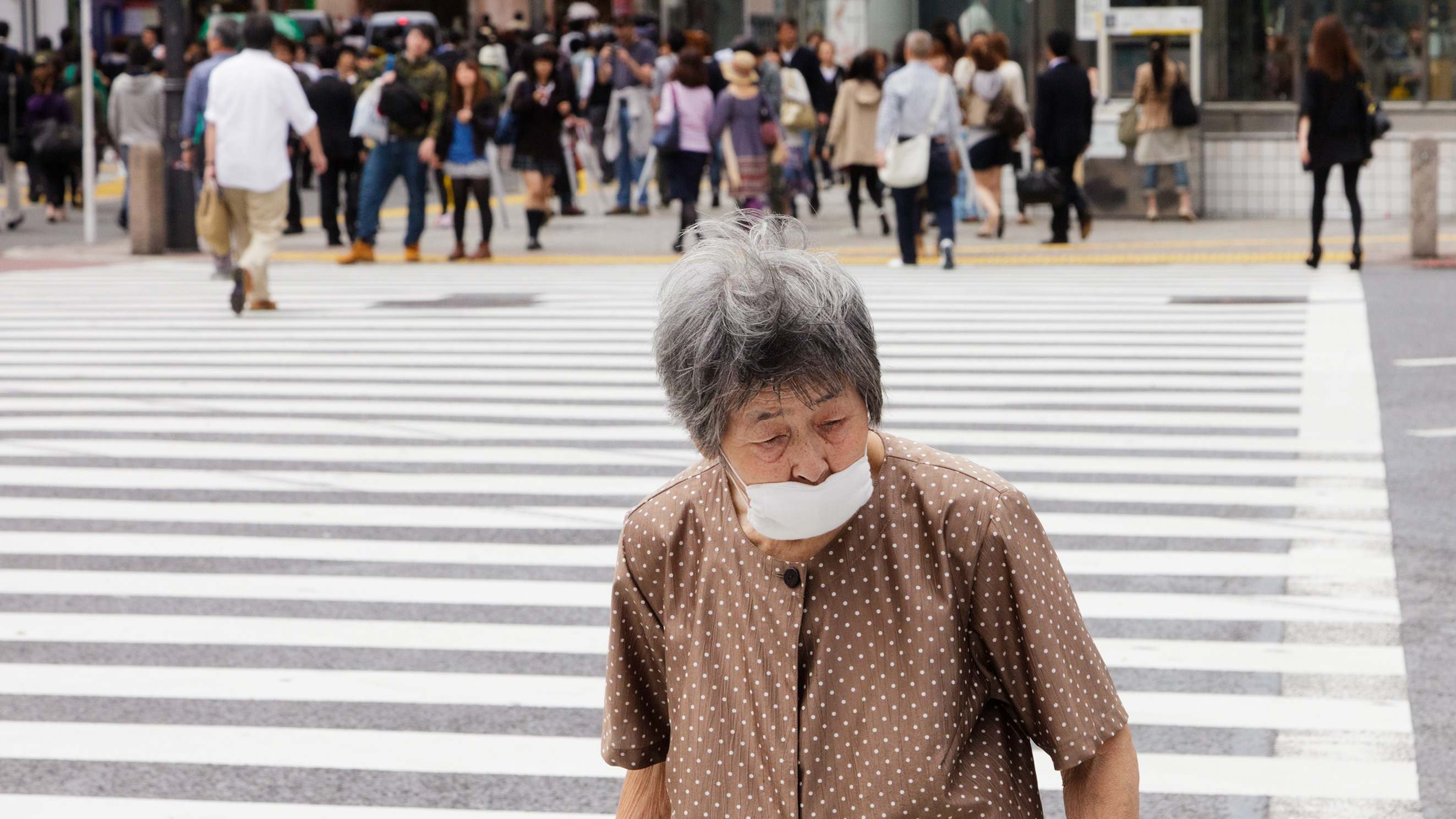 Mujer anciana en el famoso cruce de Shibuya de Tokio, Japón.