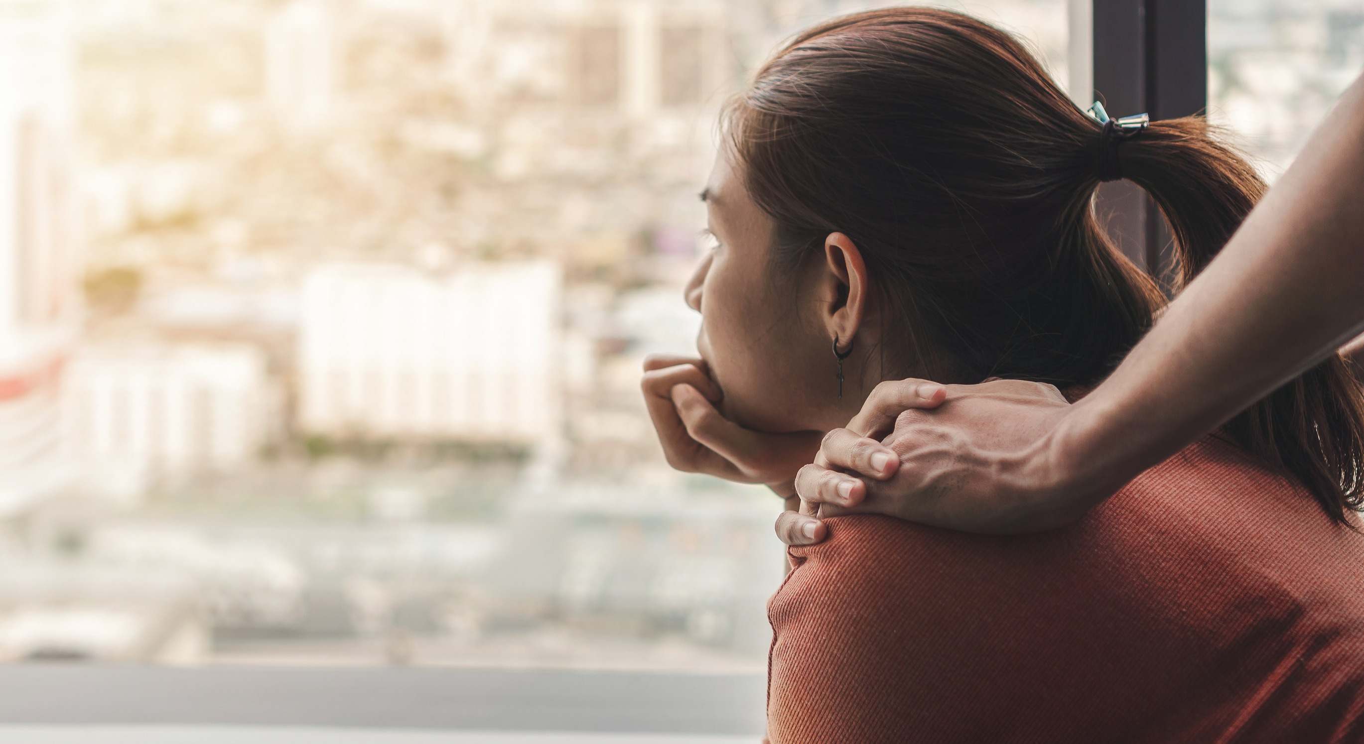 Imagen de recurso de una mujer mirando por la ventana.