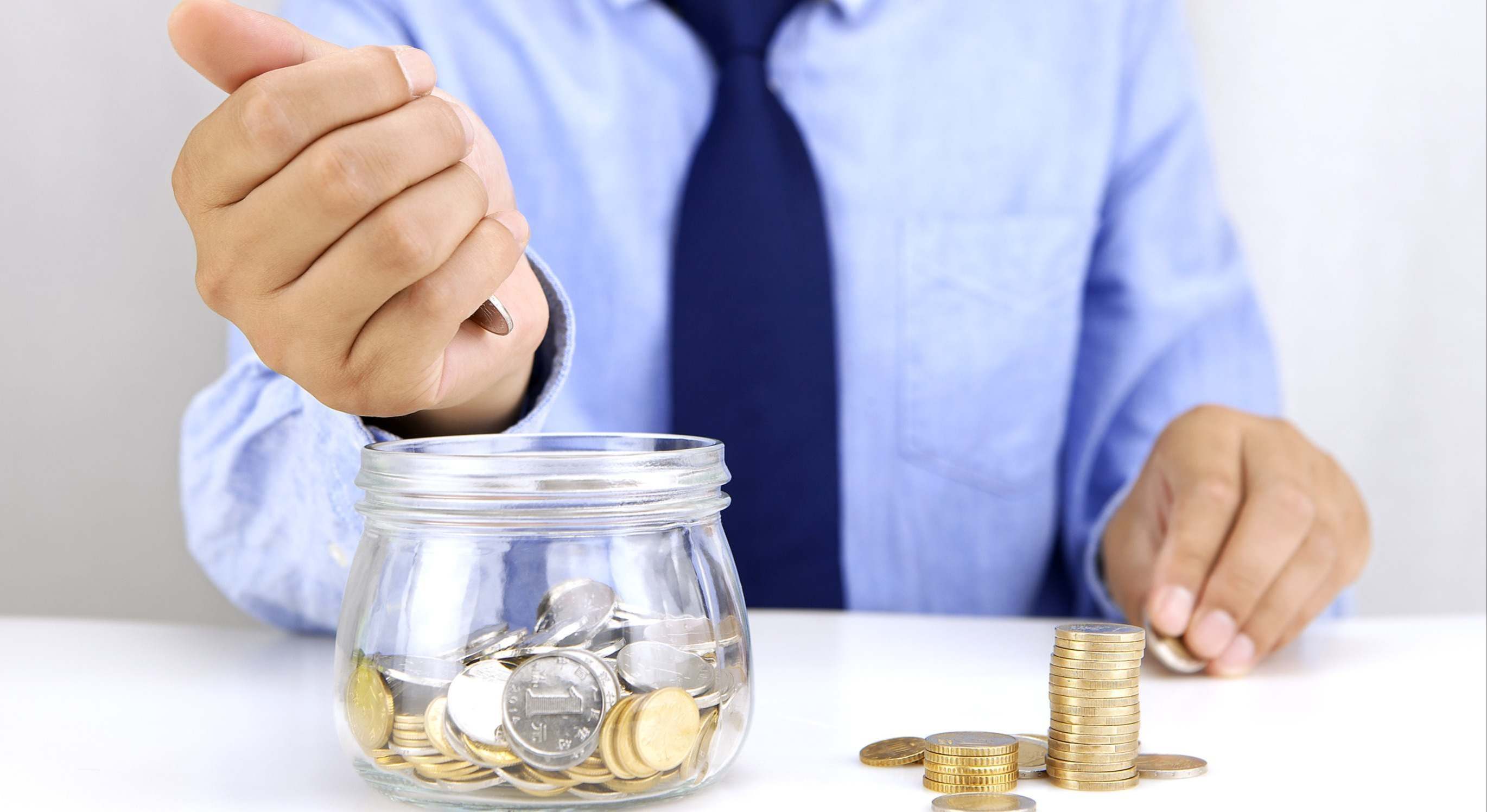 Una mano echa dinero a un bote.