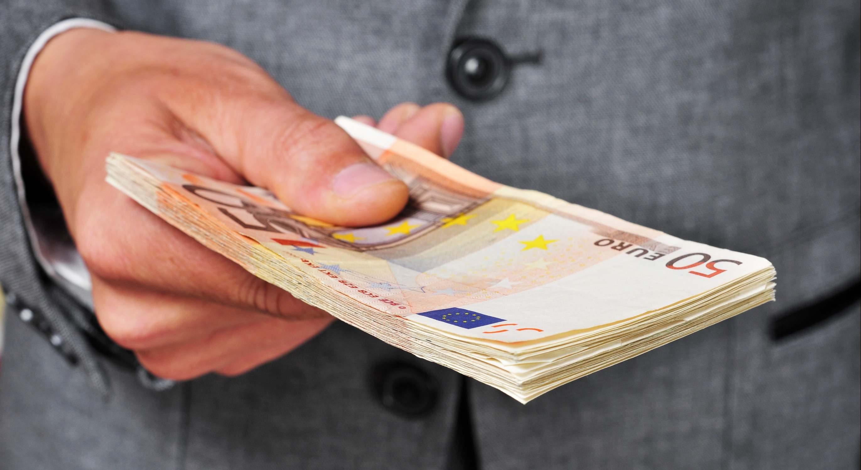 Una mano sostiene múltiples billetes de 50 euros