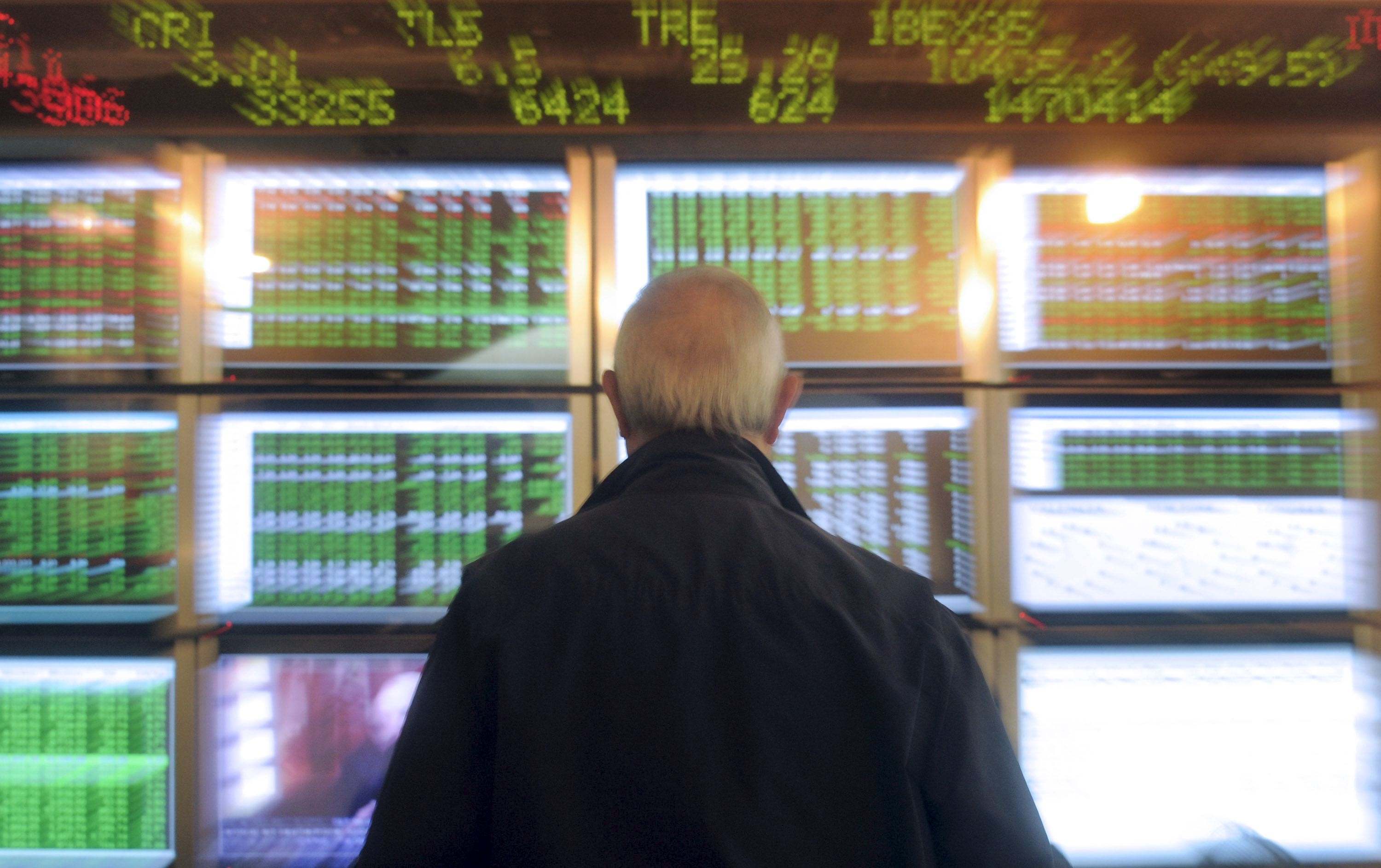Hombre mirando paneles con datos bursátiles