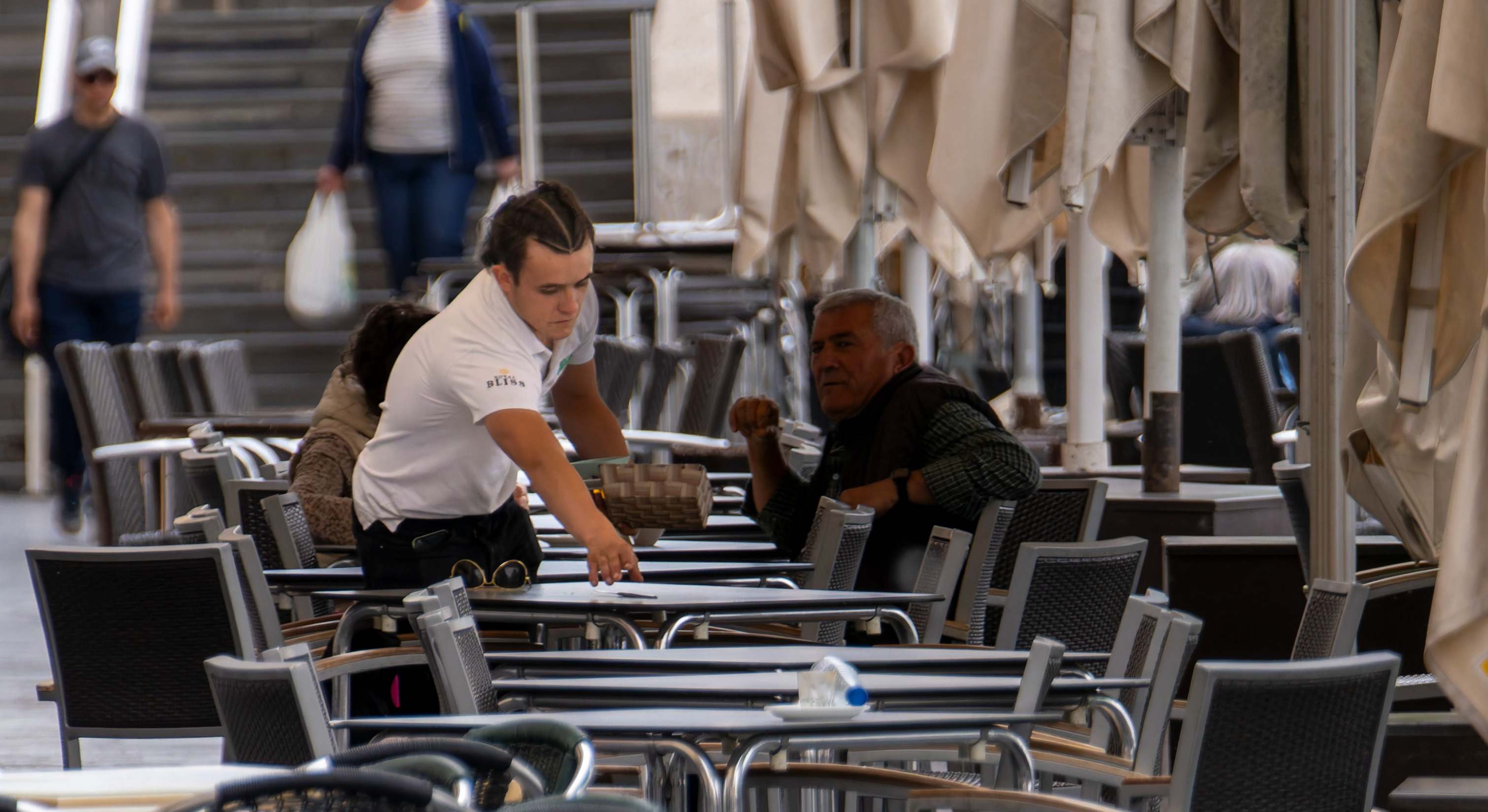 Camarero colocando las mesas de una terraza. Foto: iStock