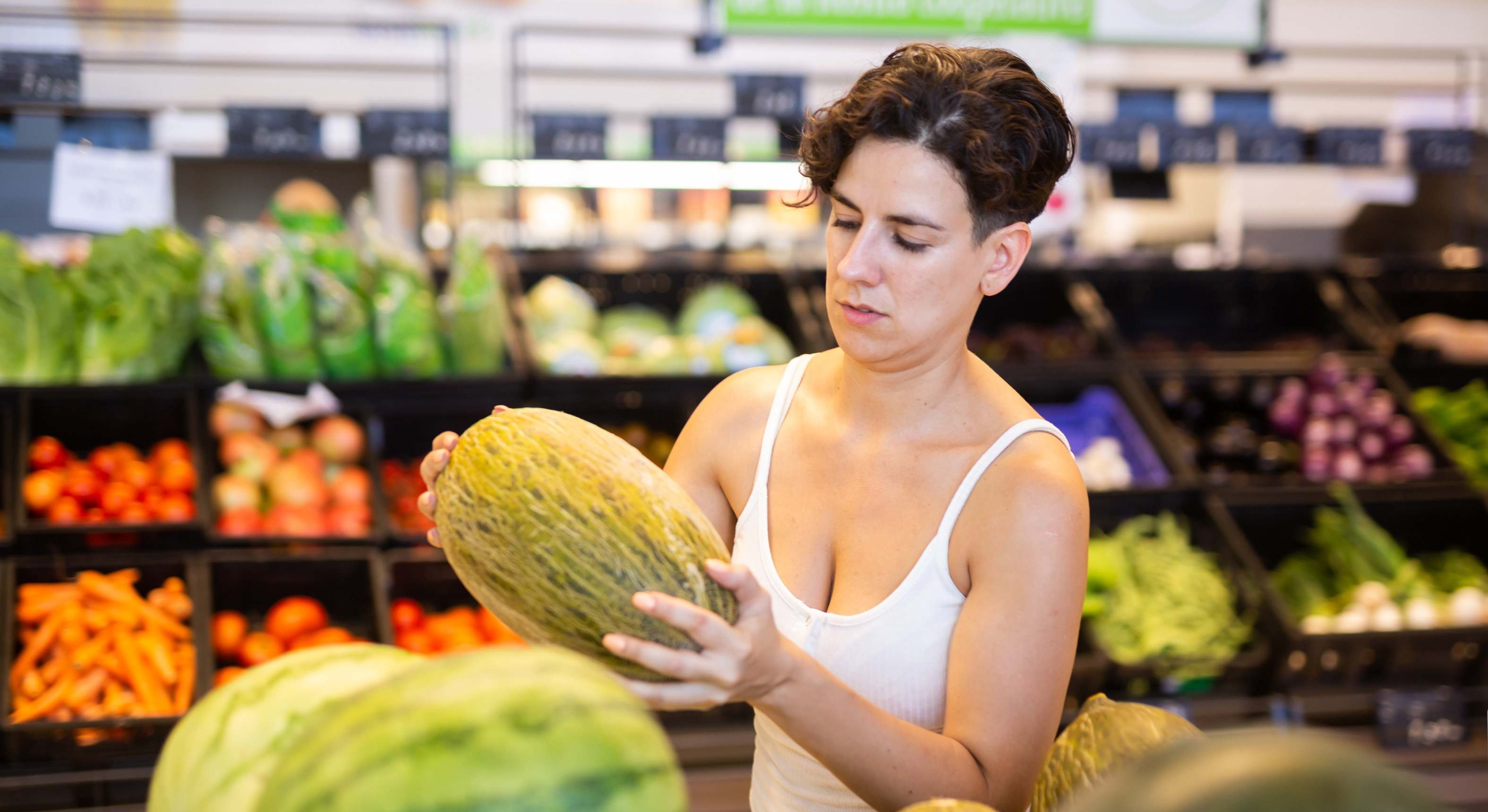 Mujer en el supermercado con un melón