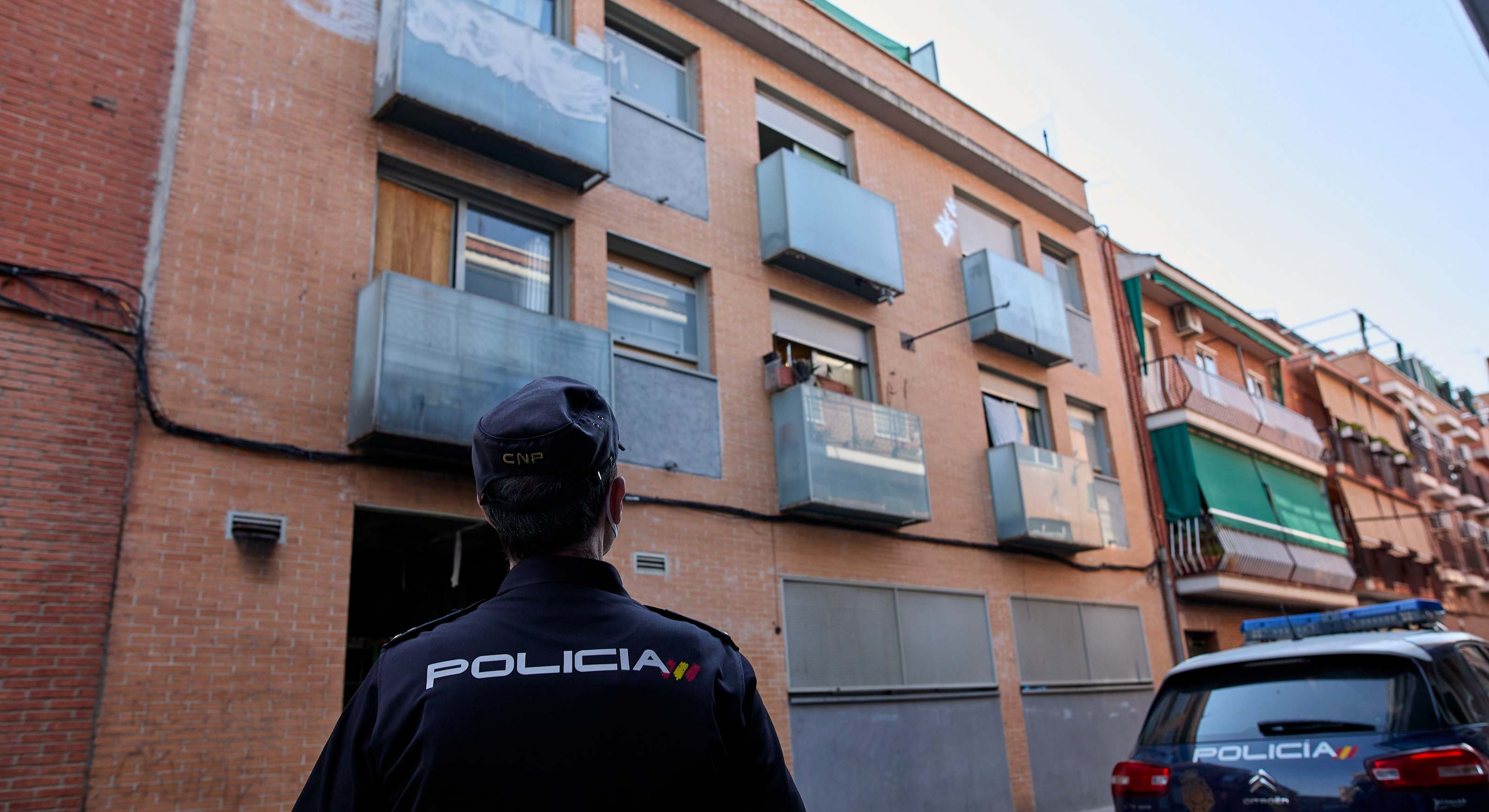 Un agente de policía delante de una vivienda 'okupada'