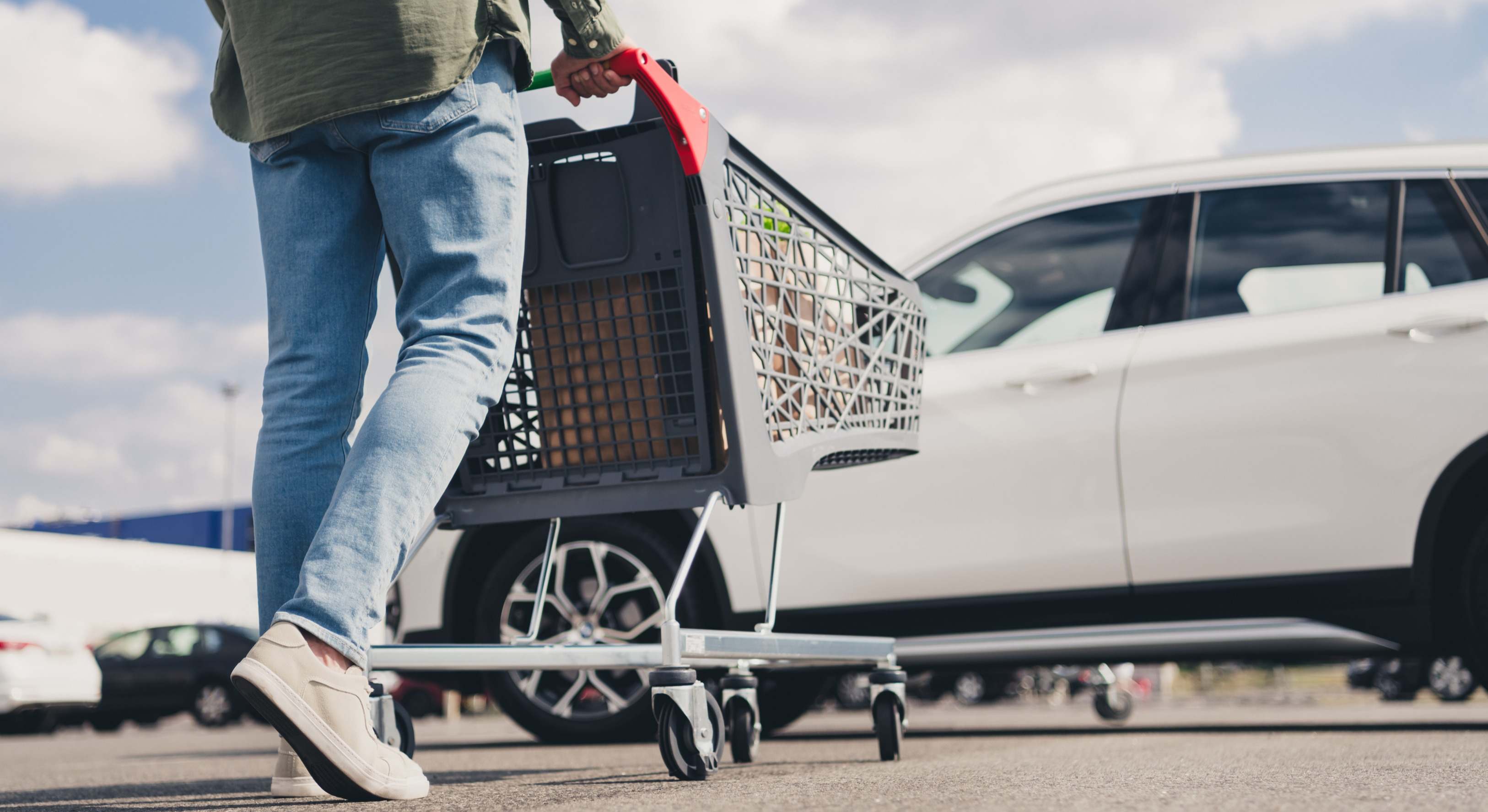 Hombre con el carrito de la compra yendo al coche