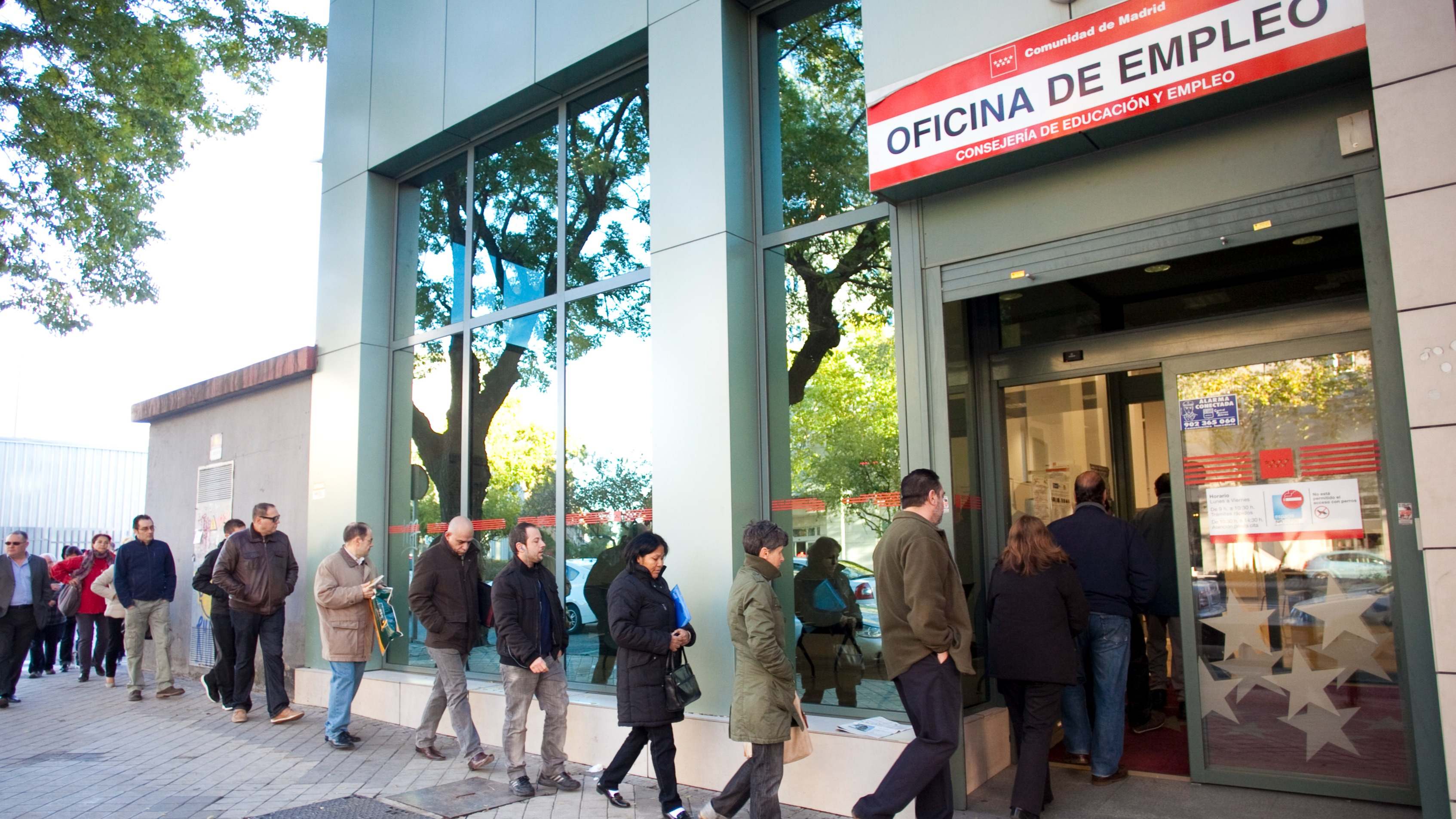 Varias personas hacen cola en una oficina de empleo