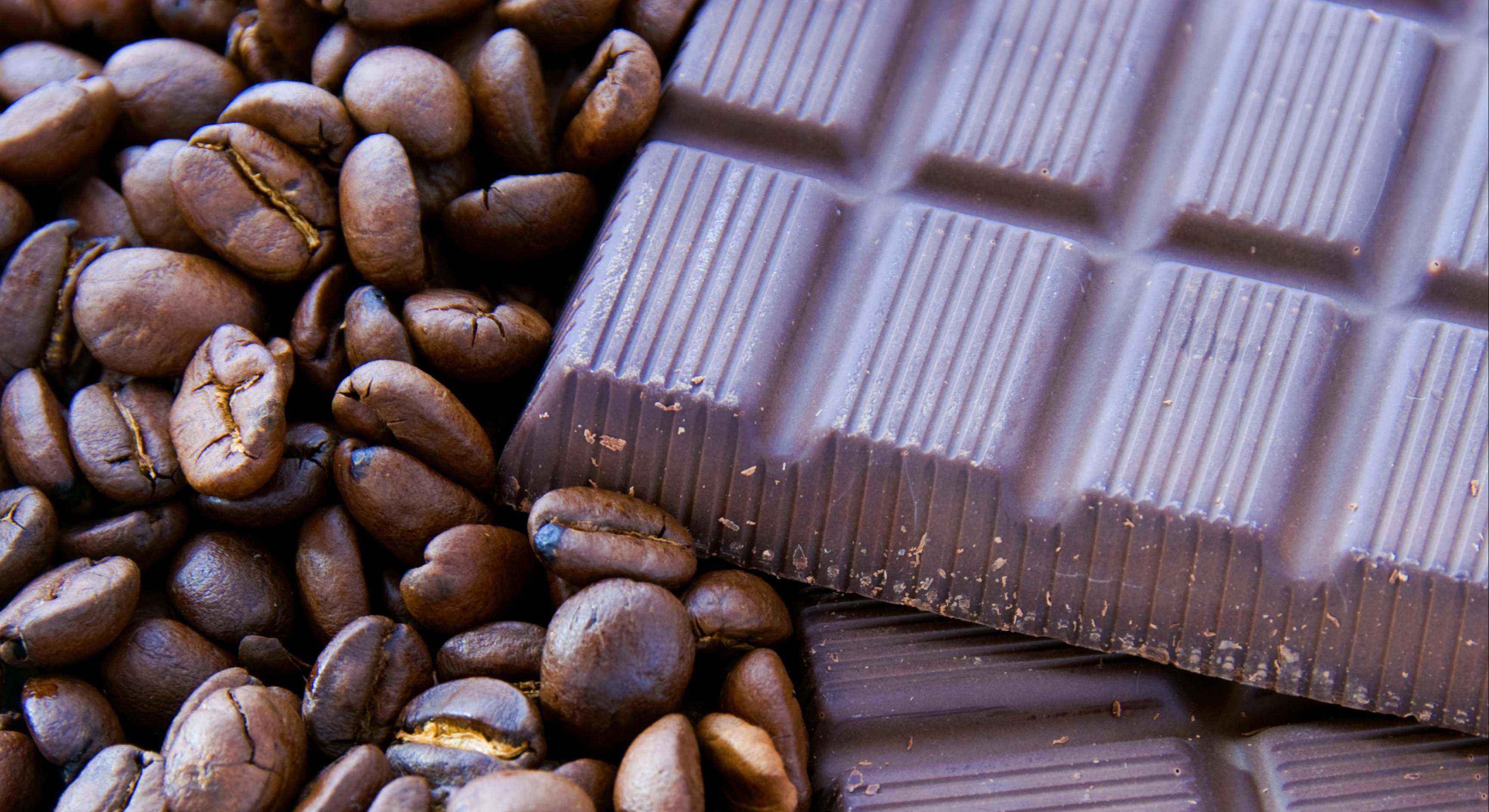Granos de café al lado de una tableta de chocolate