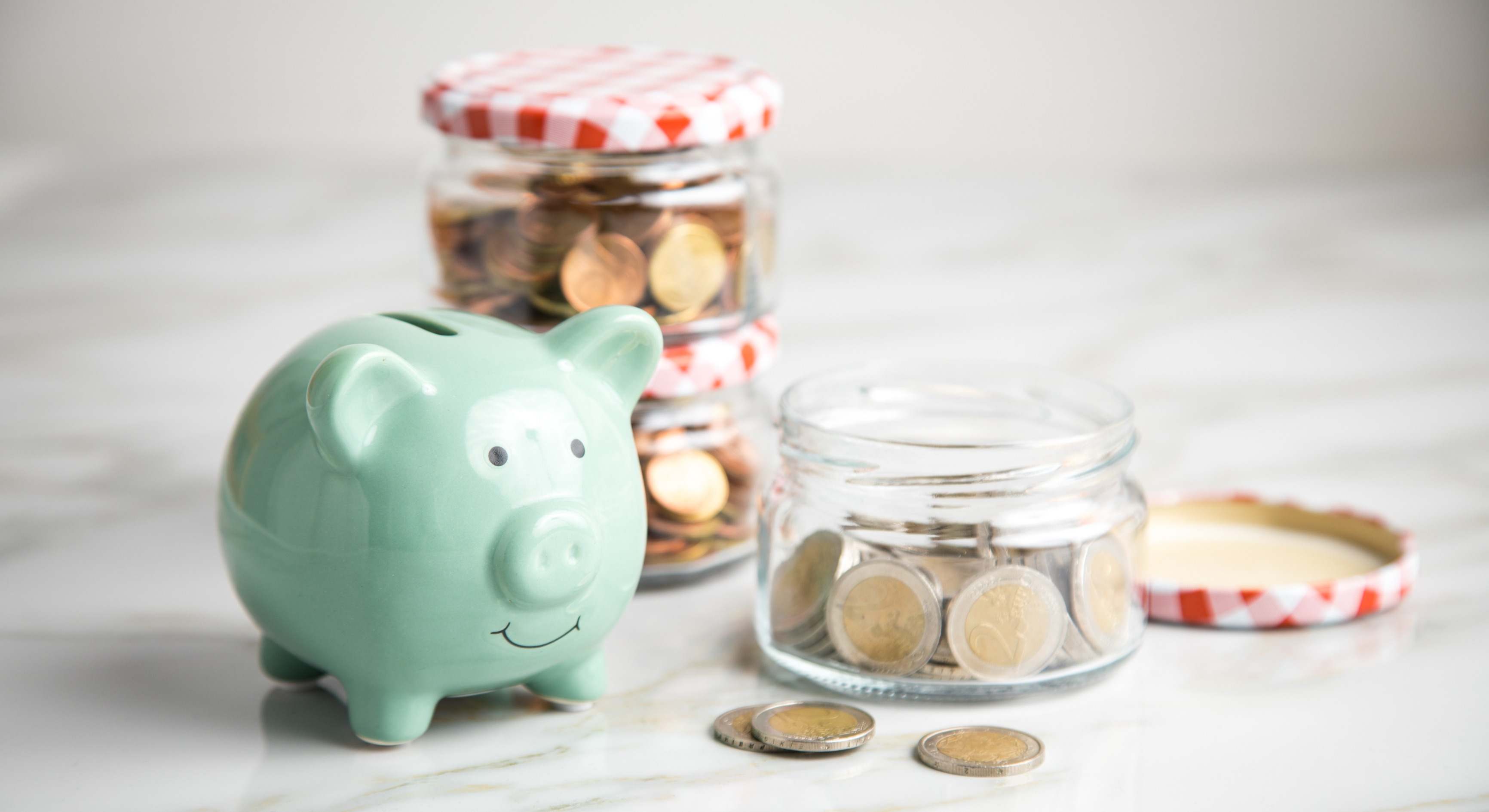 Botes con monedas al lado de una hucha