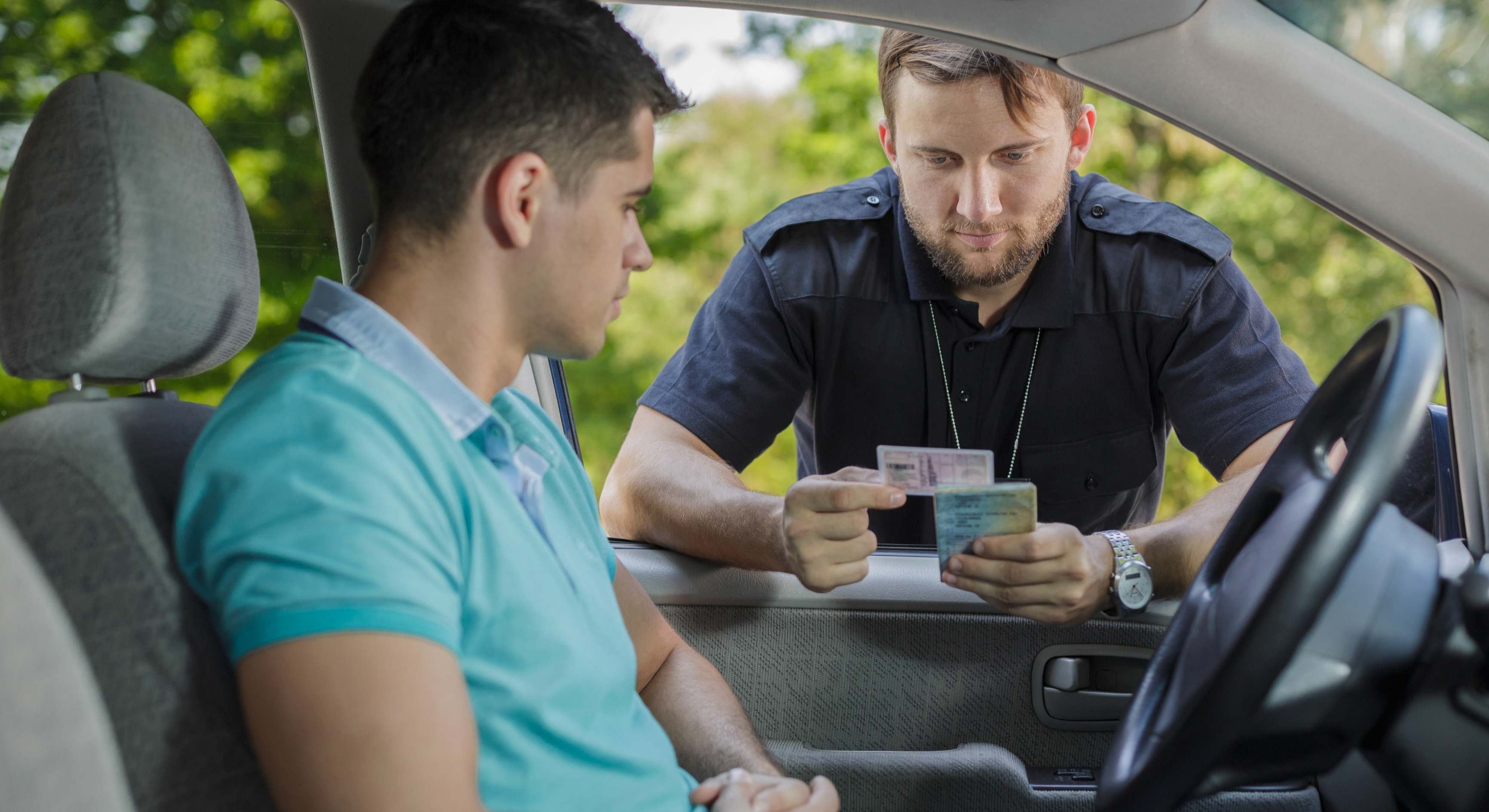 Un policía comprueba el carnet de conducir de un joven