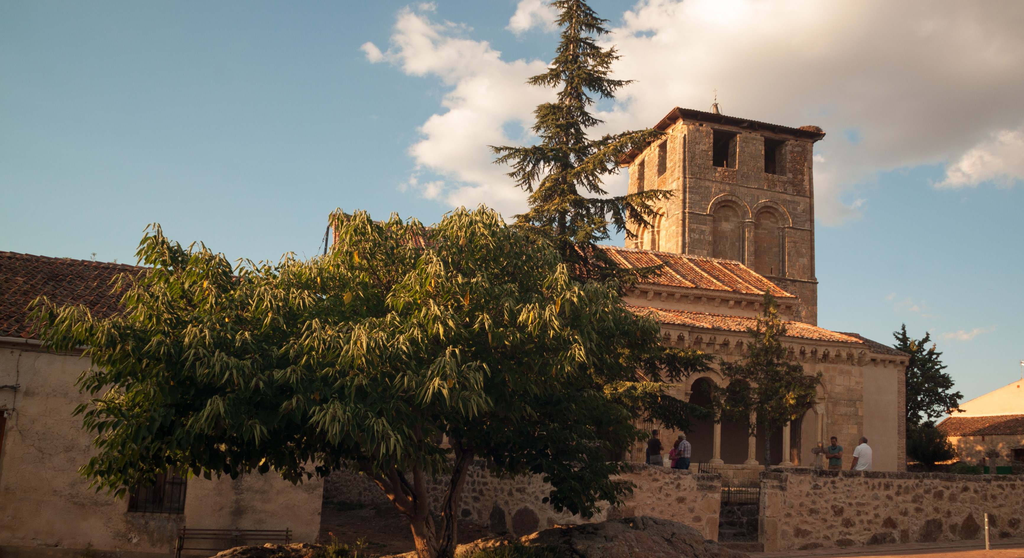 La iglesia de Sotosalbos con árboles y nubes