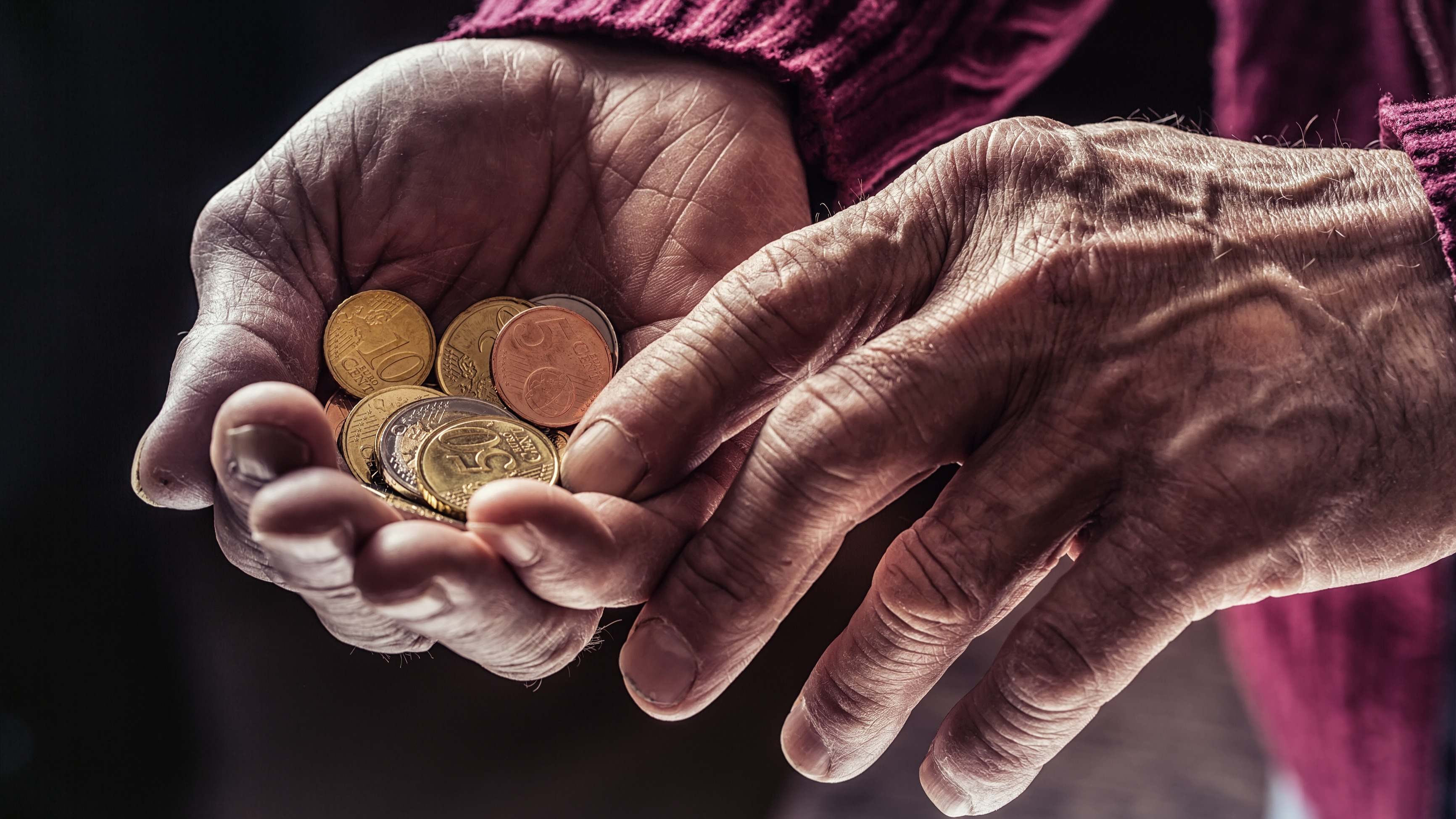 Una persona mayor sostiene unas monedas en su mano
