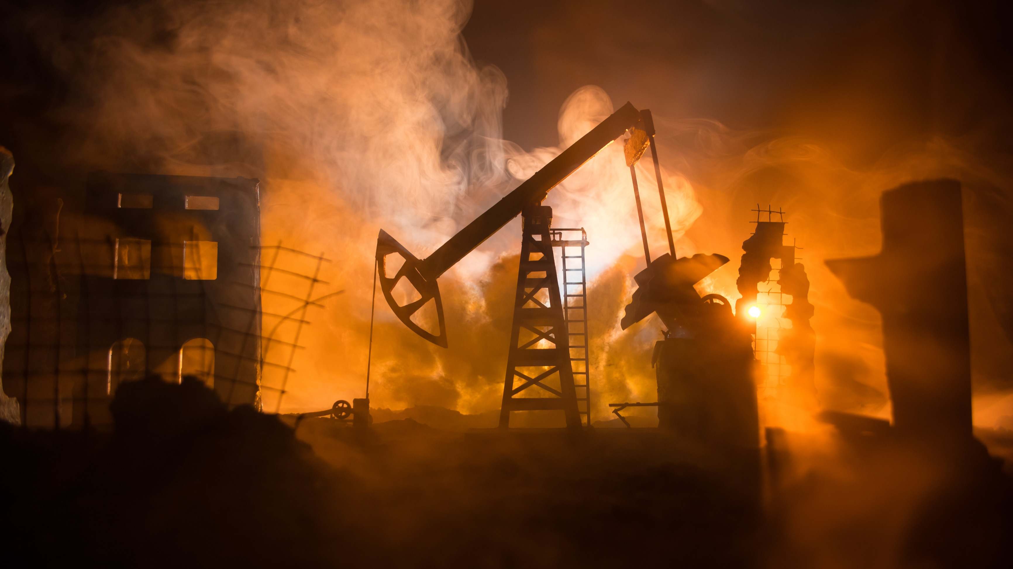 Un pozo de petróleo entre el humo de un conflicto bélico