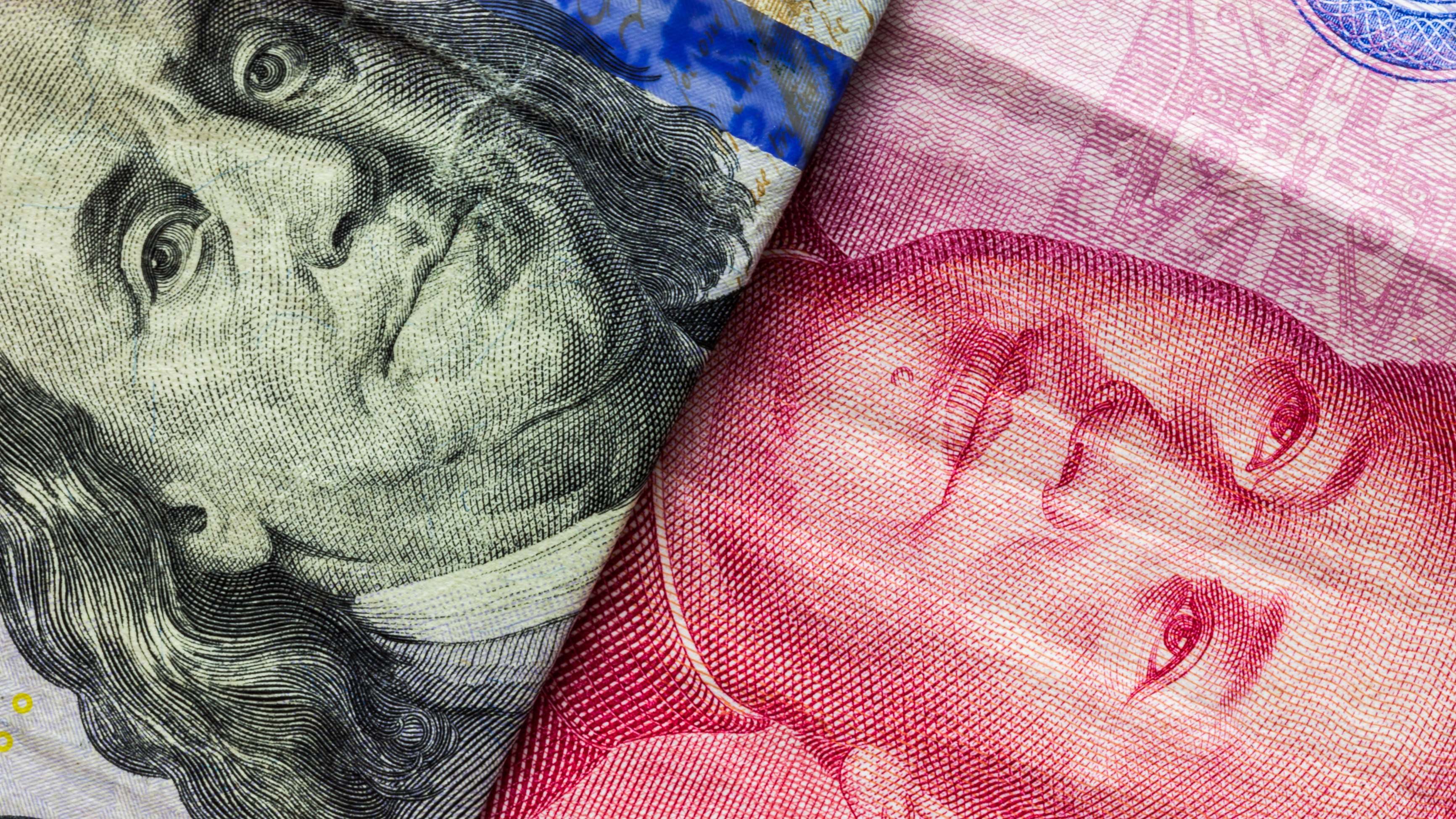 Un billete de dólar enfrentado a un billete de yuan