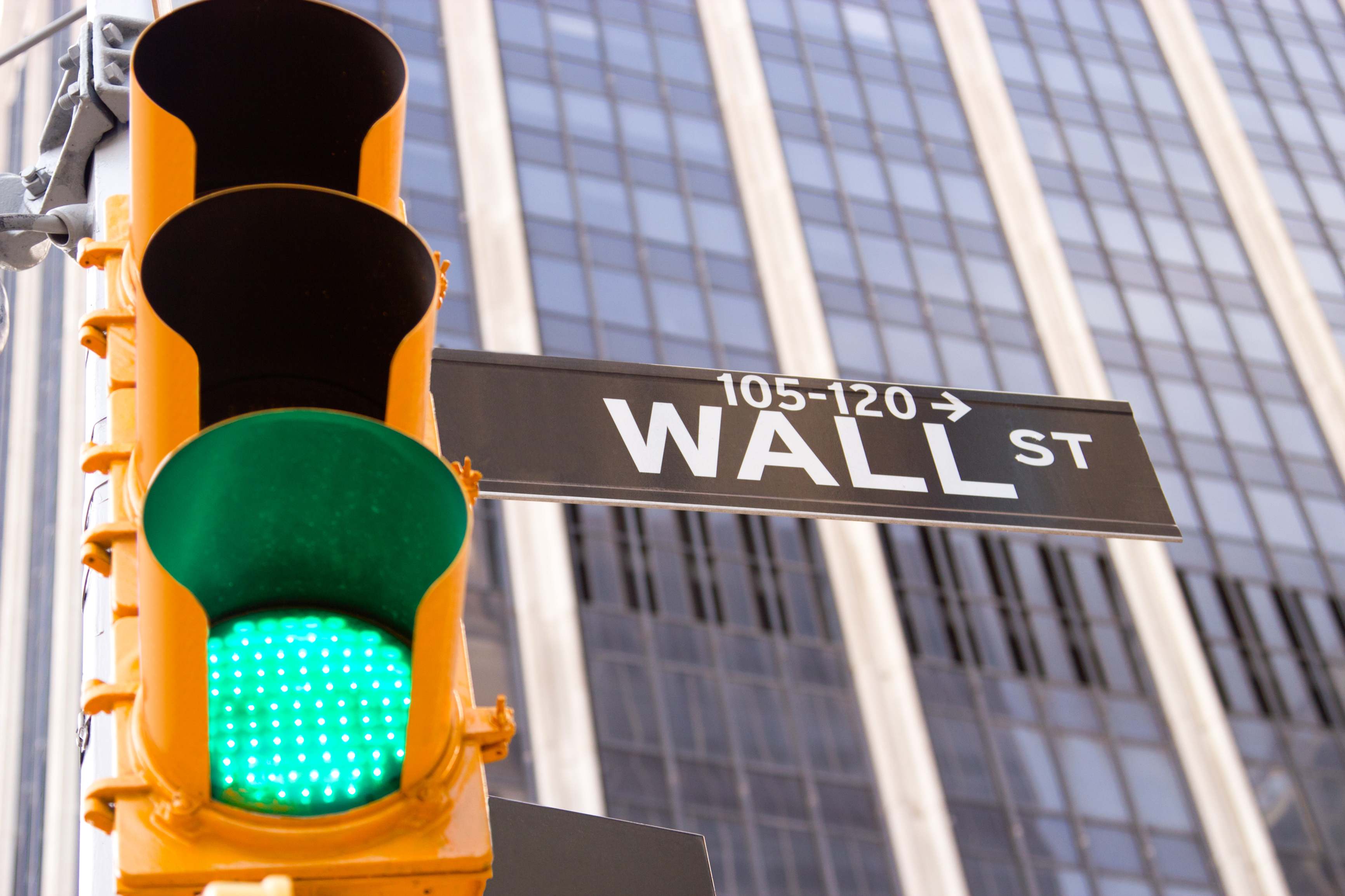 Un semáforo en verde sobre el cartel de Wall Street