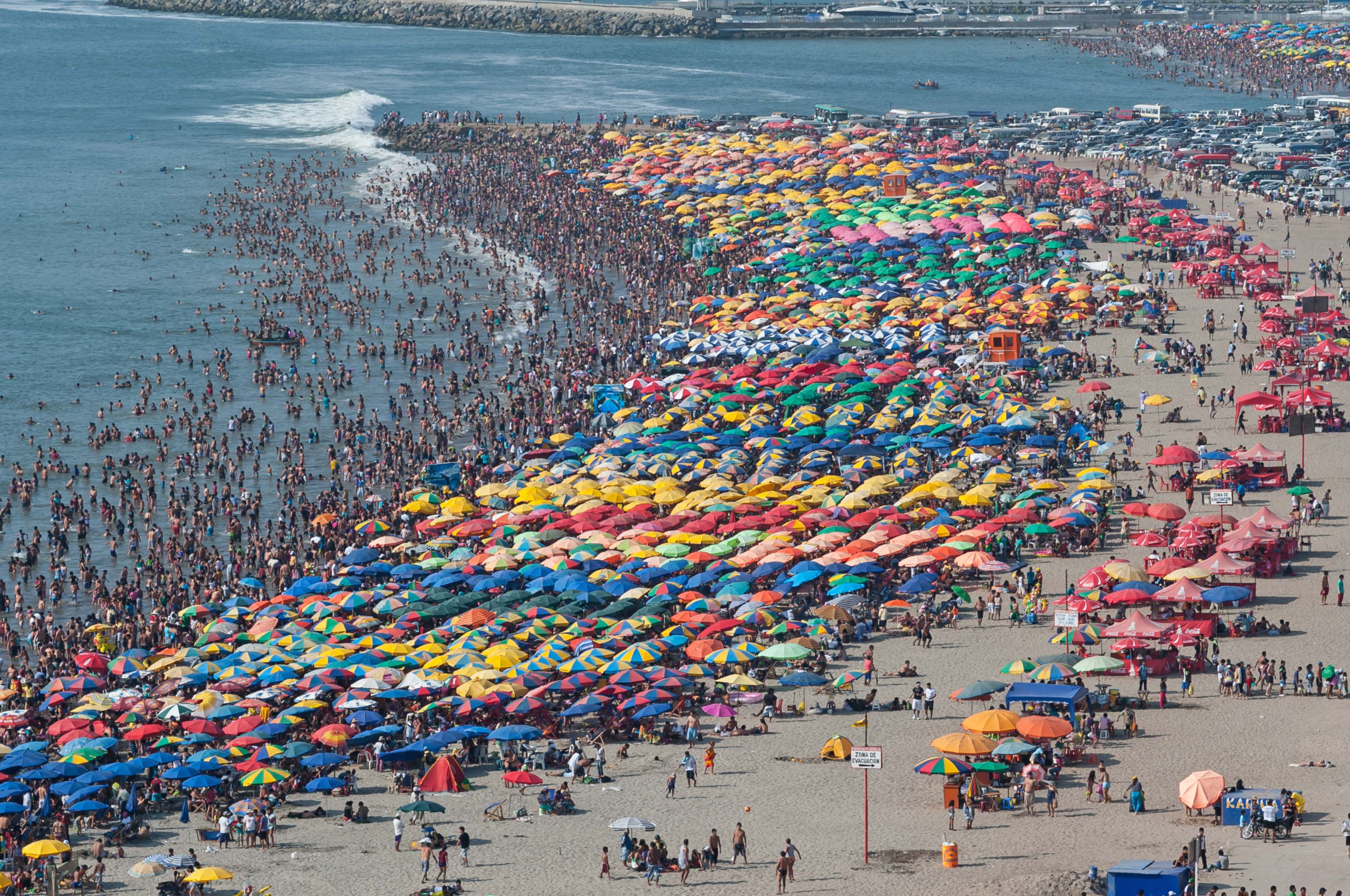 Una playa abarrotada, llena de gente.