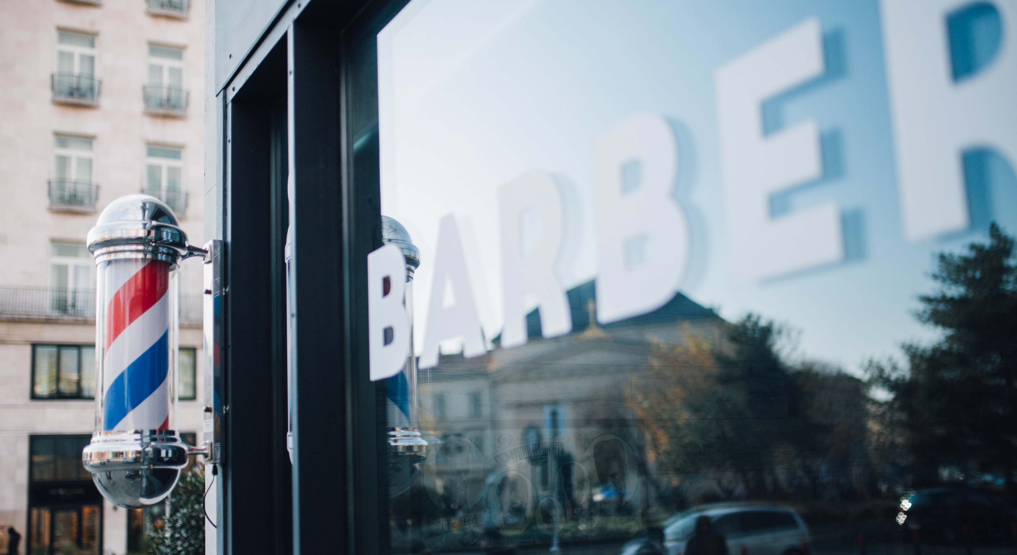 Poste rojo, blanco y azul a la puerta de una barbería. / Foto: iStock