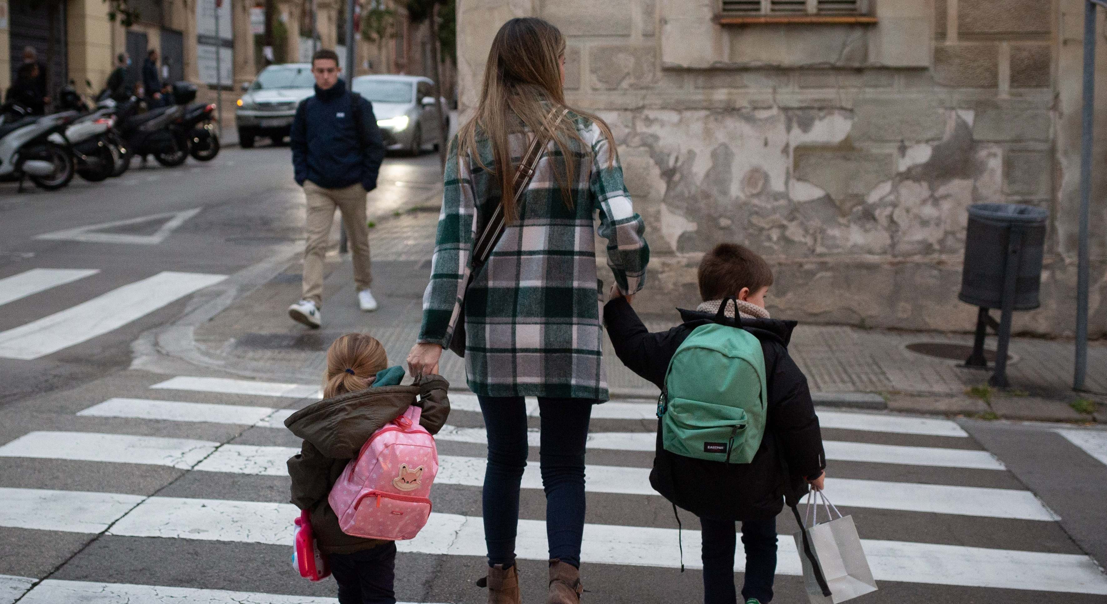 Una mujer lleva a los niños al colegio