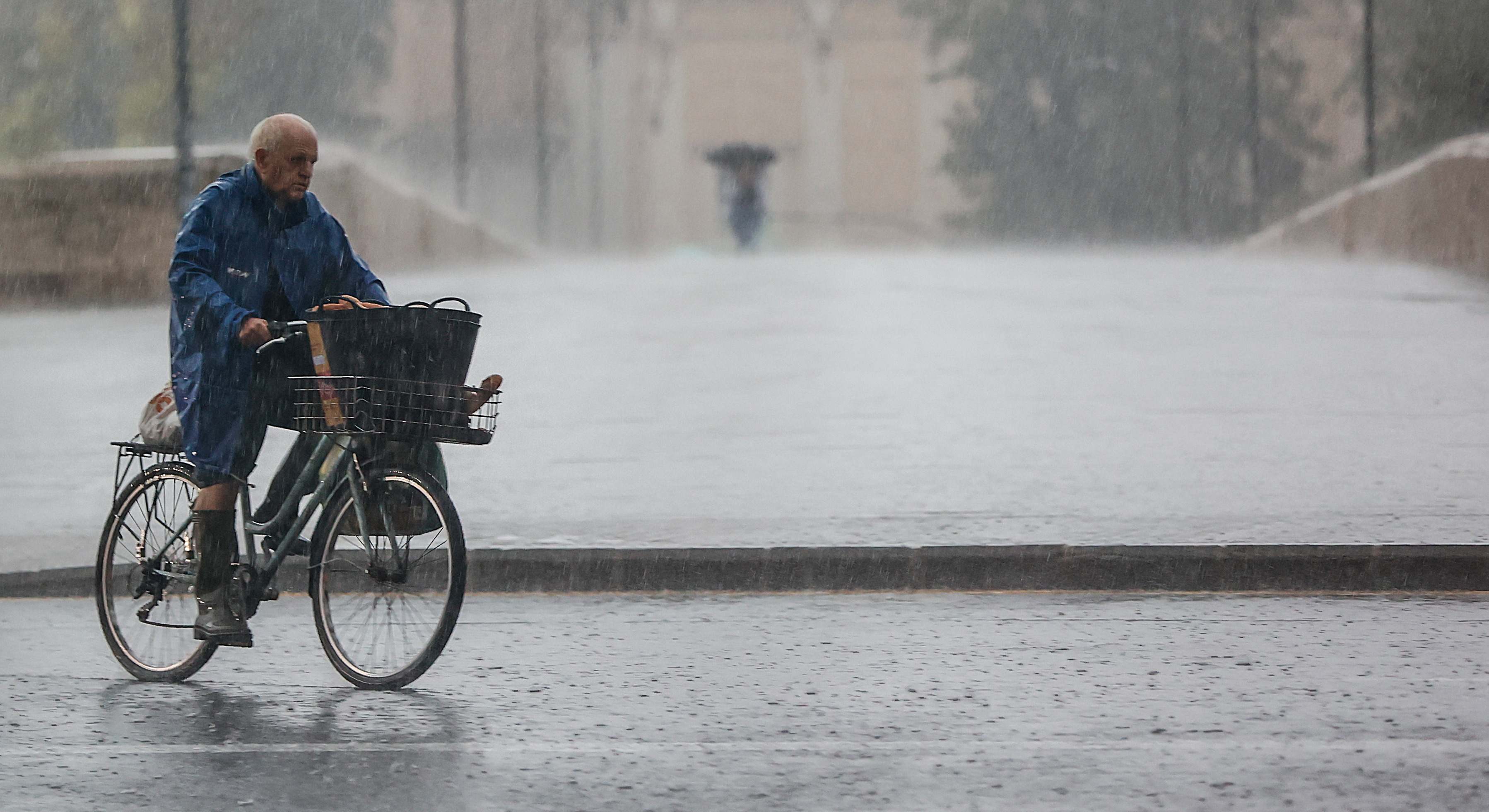 Imagen de archivo de un hombre montando en bicicleta bajo la lluvia. Foto: Rober Solsona / EP.