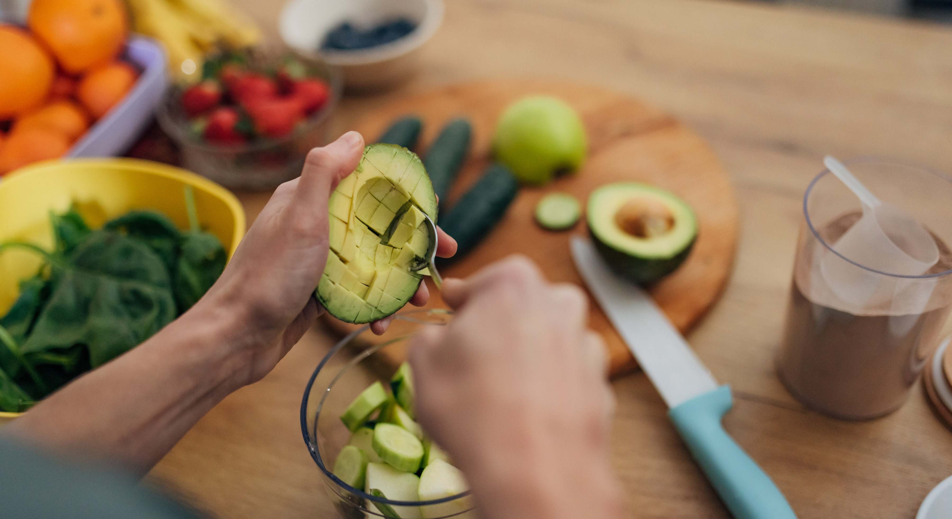 Manos de una persona partiendo un aguacate