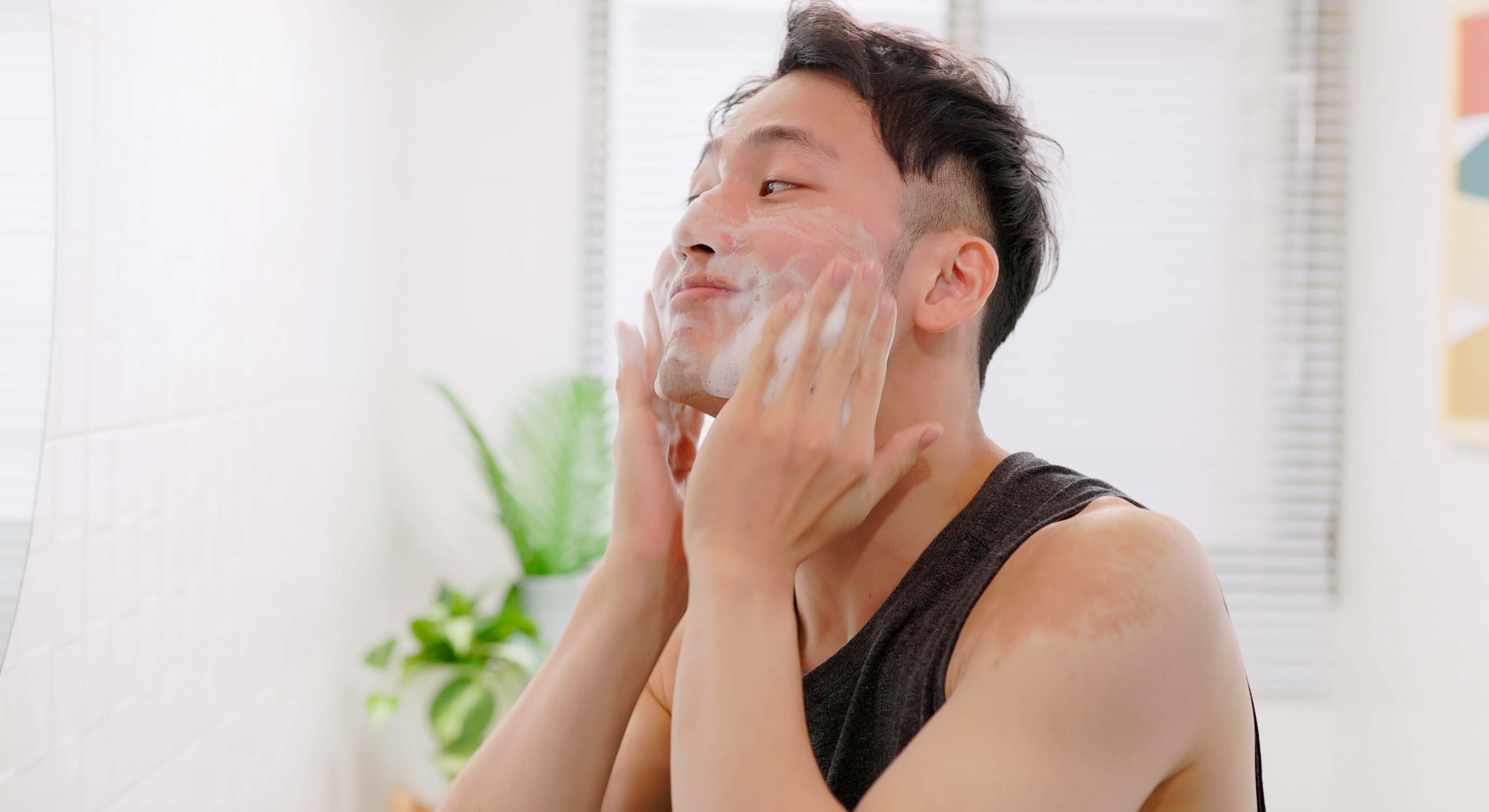 Hombre lavándose la cara con jabón y espuma