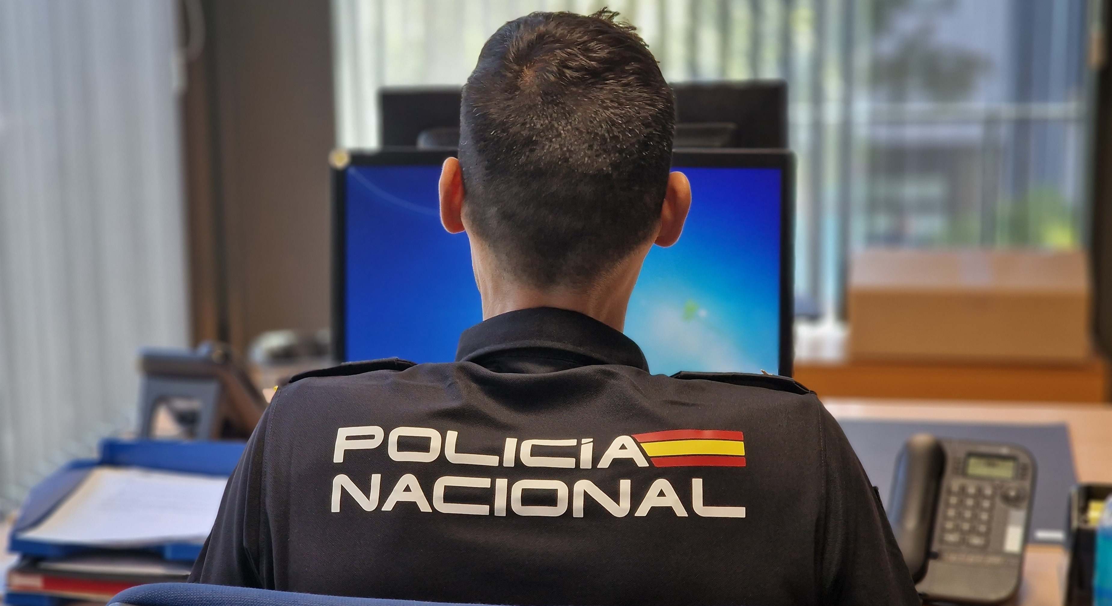 Un Policía Nacional delante de un ordenador