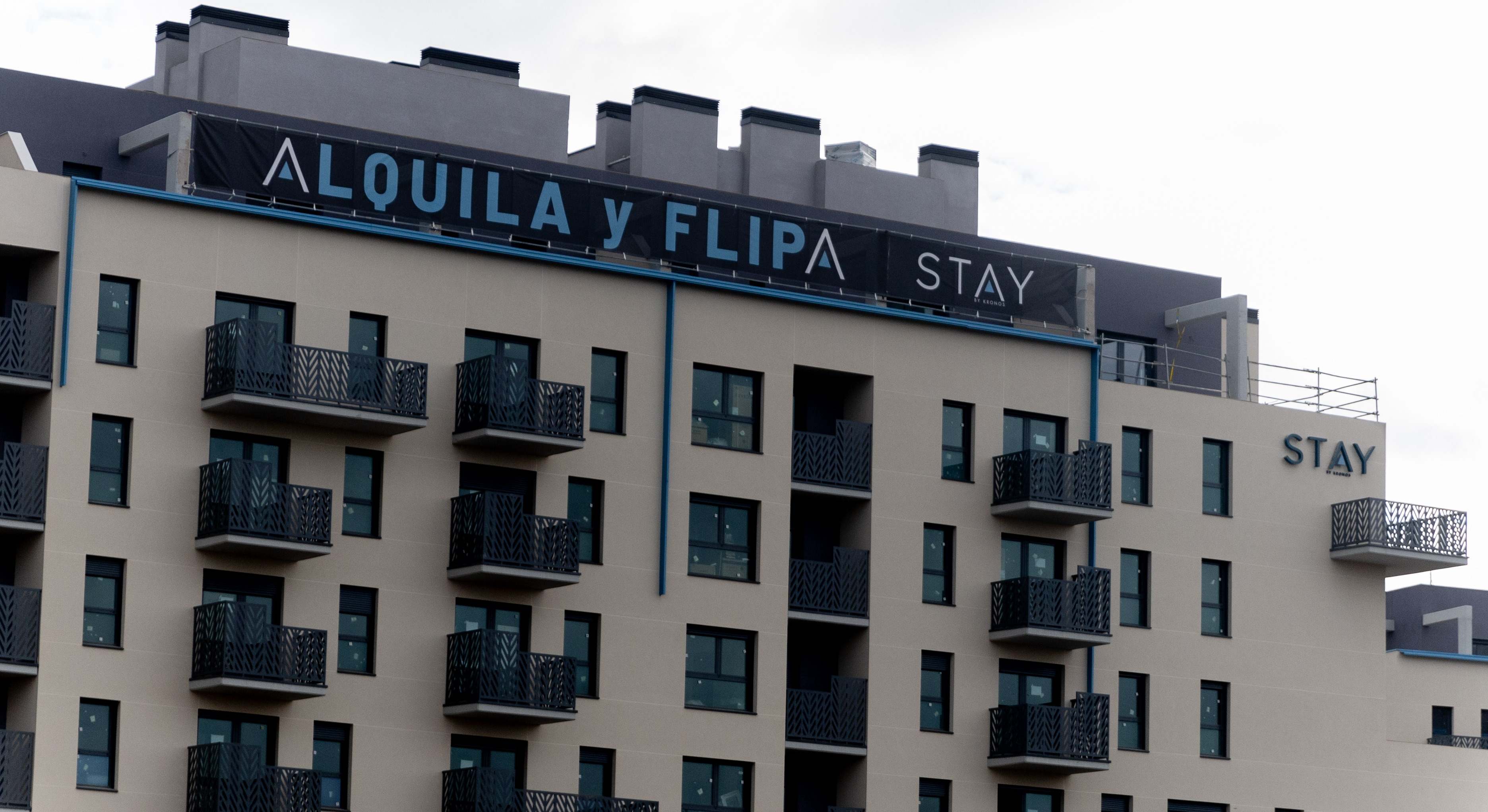 Un edificio con un cartel anunciando alquileres en Madrid.