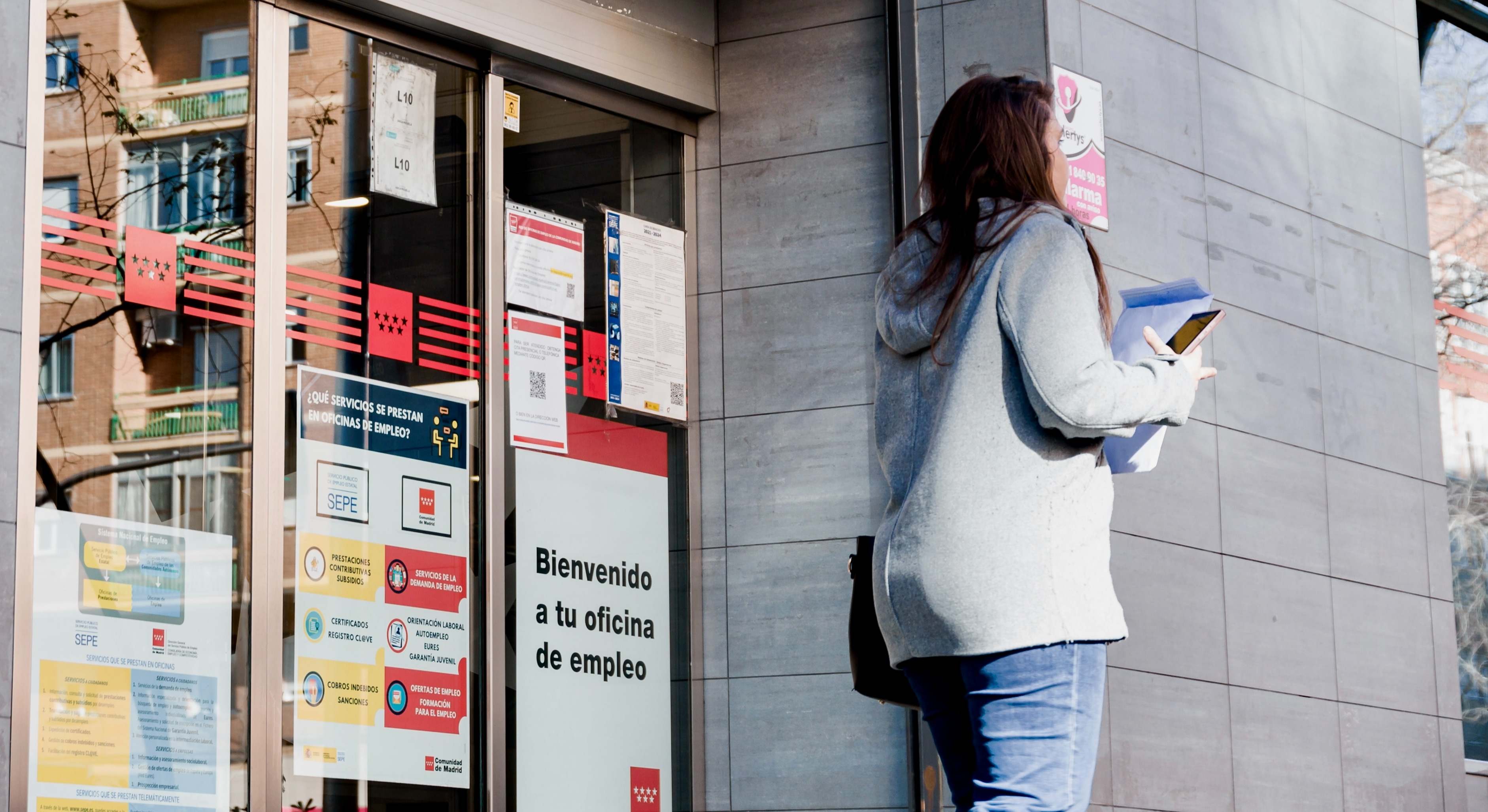 Imagen de recurso de una mujer frente a una oficina del SEPE.