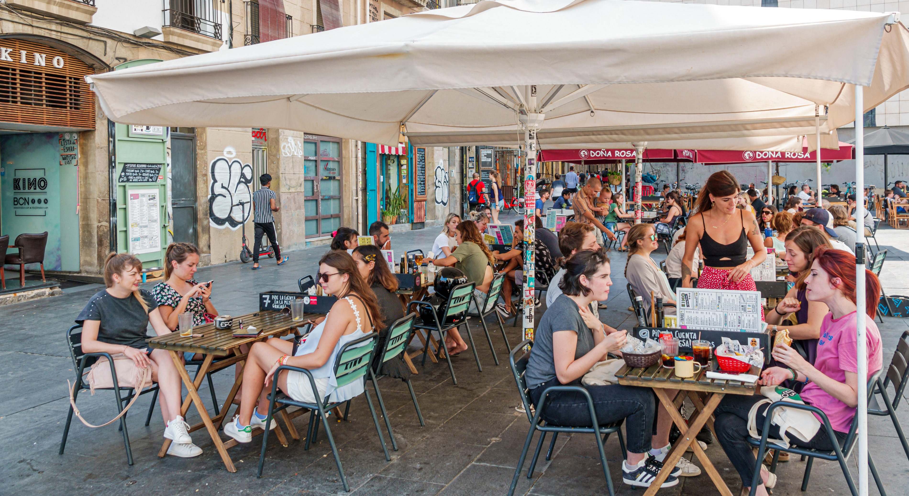 Camarera atendiendo la terraza de un bar de Ciutat Vella, Barcelona. Foto: Alamy