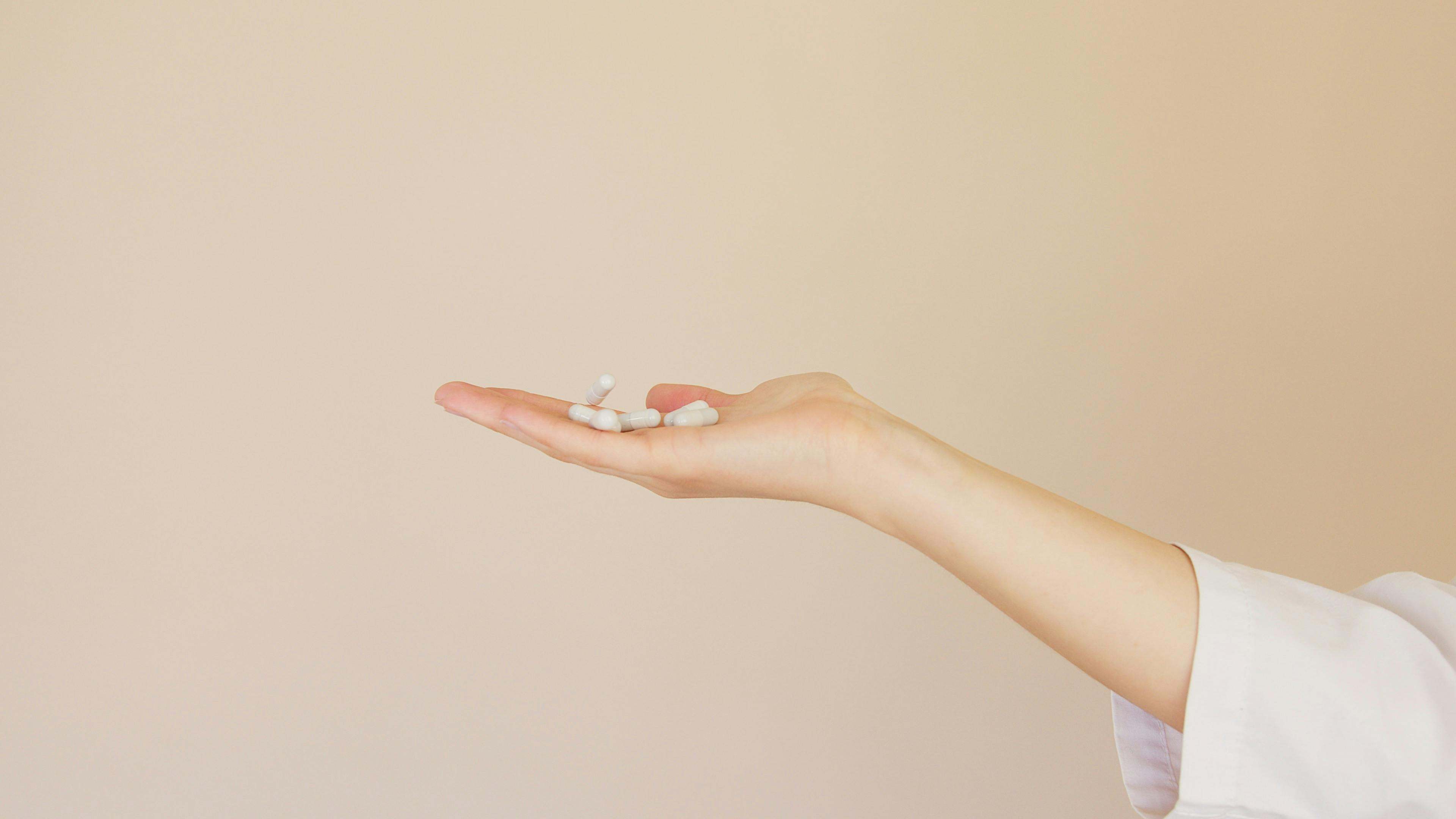 Varios suplementos en la mano de una mujer