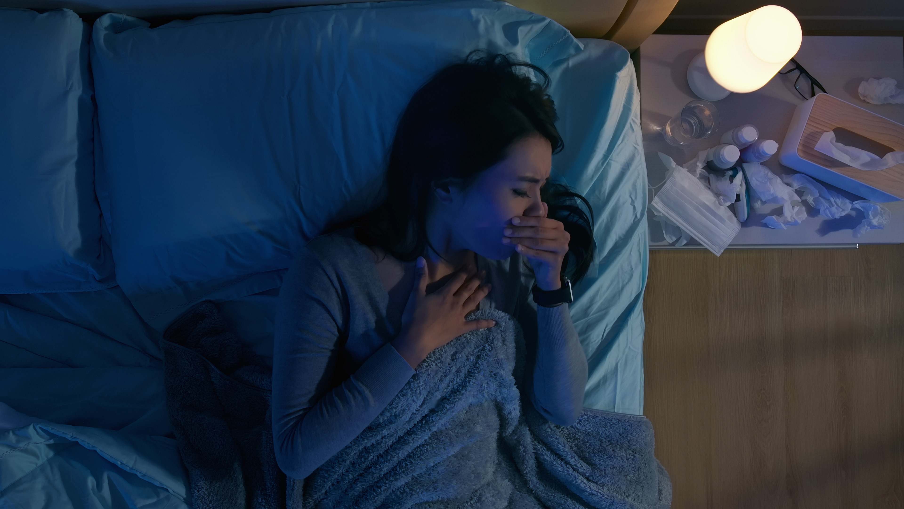 Mujer tose en su cama por la noche