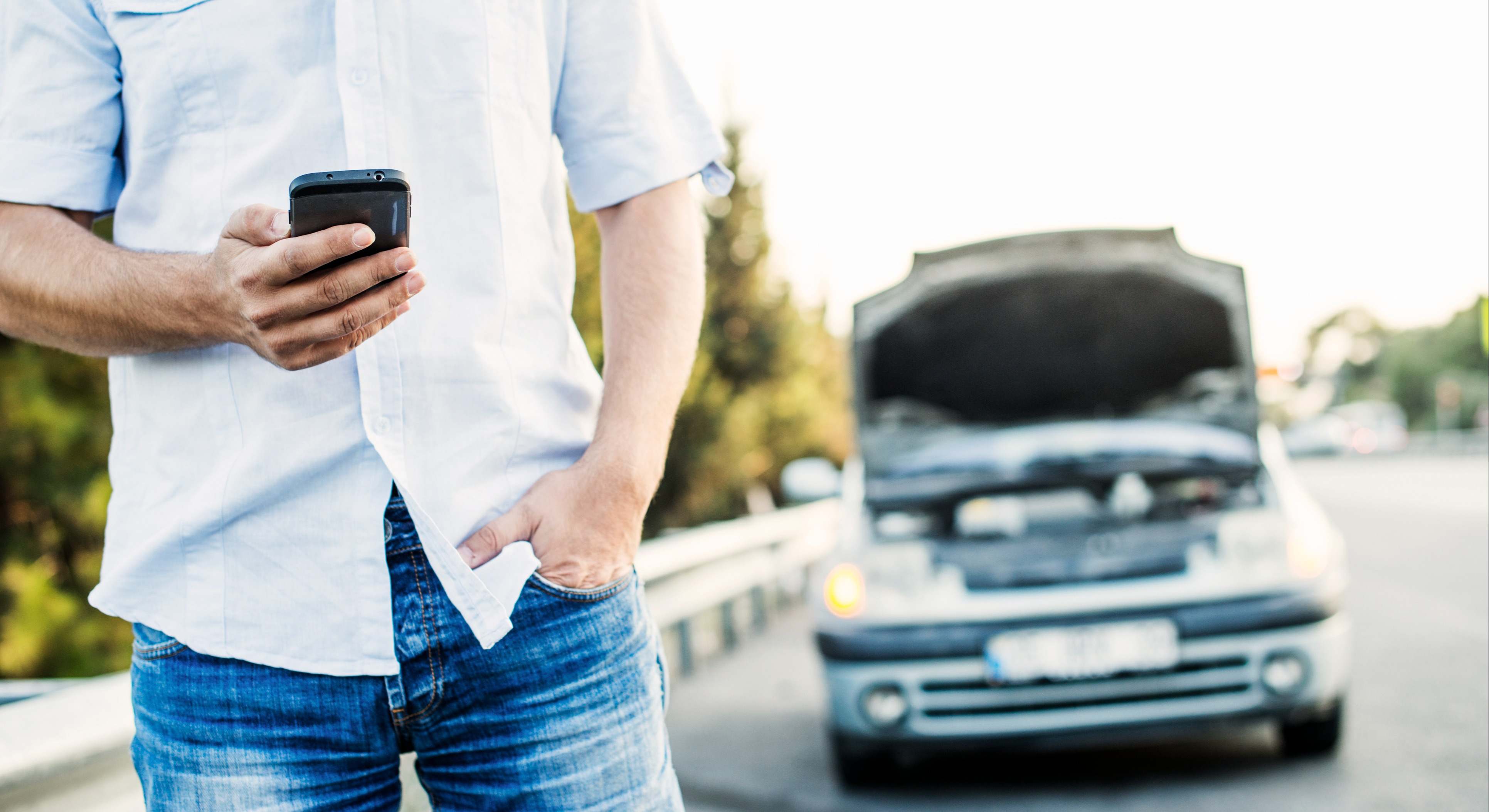 Avería de coche mientras hombre llama por teléfono a asistencia de carretera