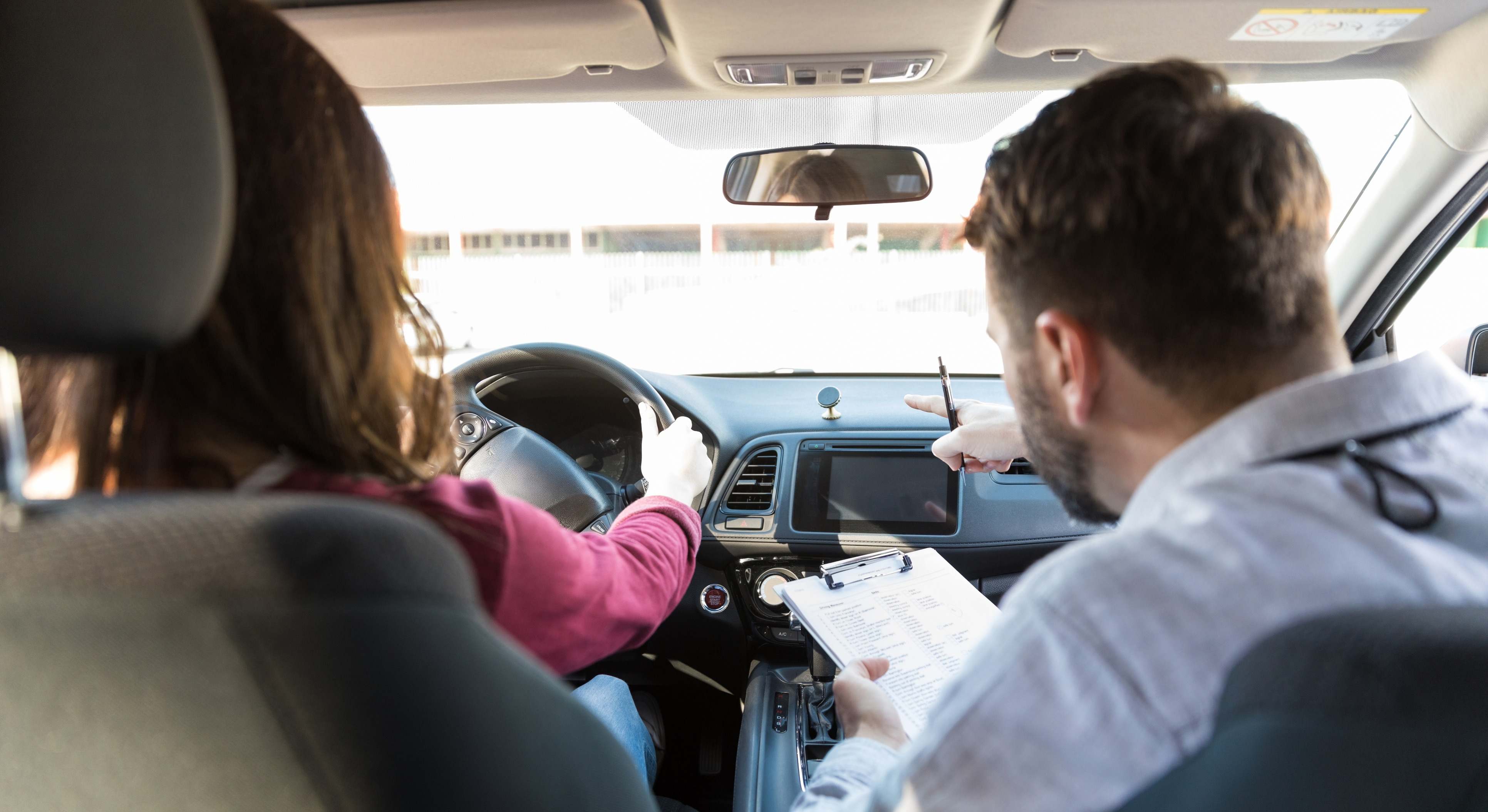 Instructor guía a un estudiante en el coche