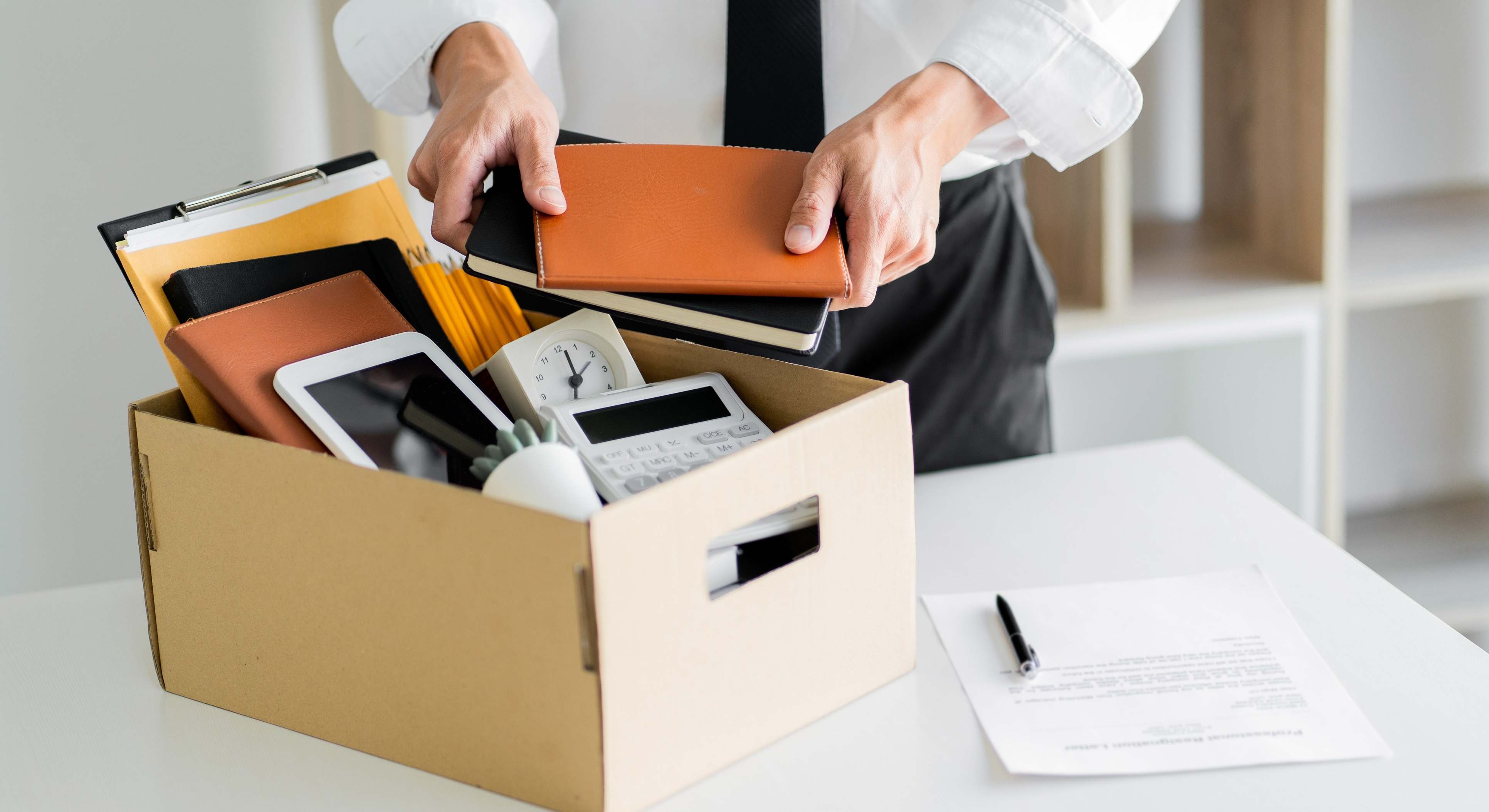 Una persona mete en una caja sus enseres de trabajo