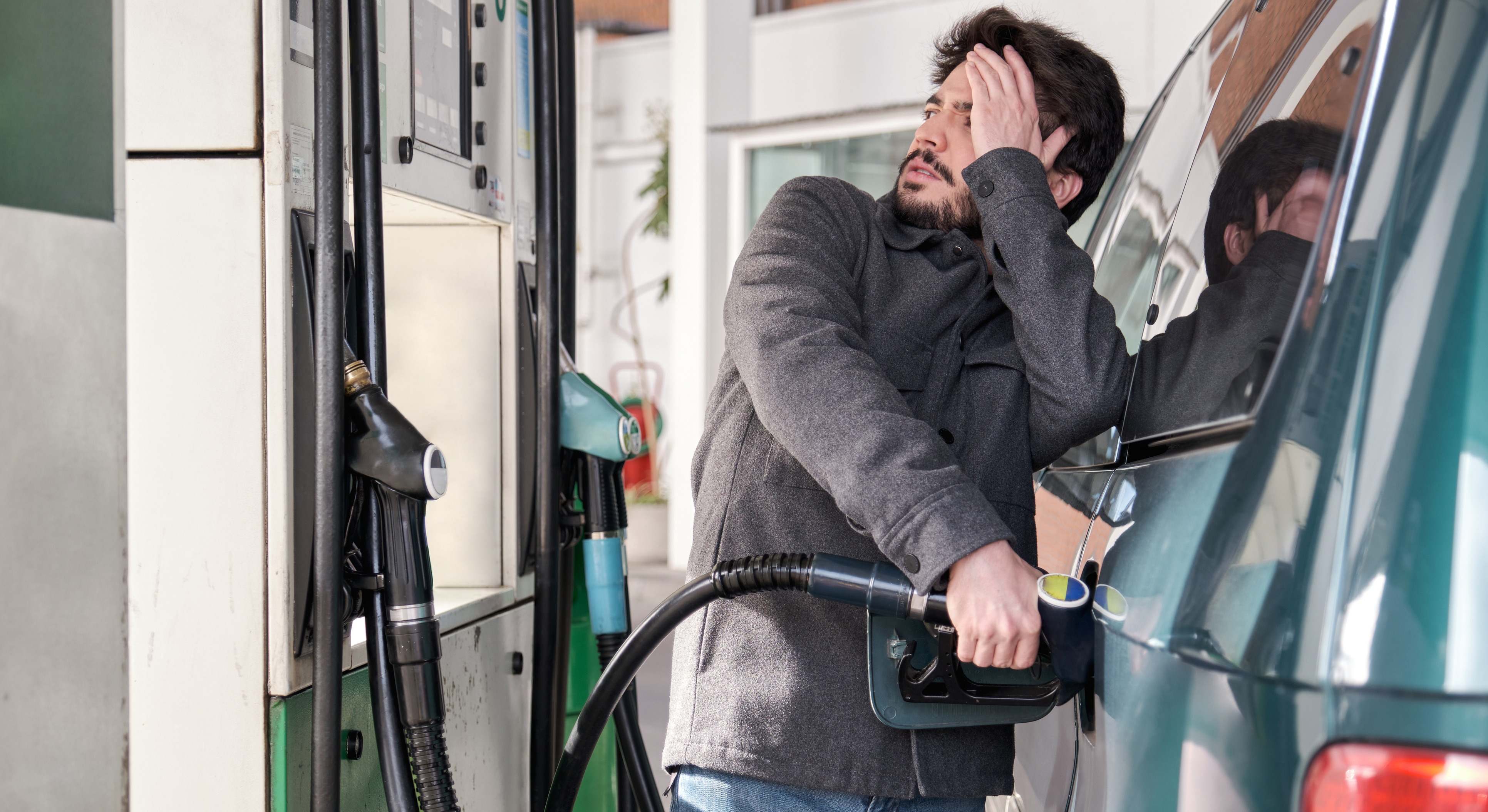 Conductor llenando el depósito del coche en una gasolinera