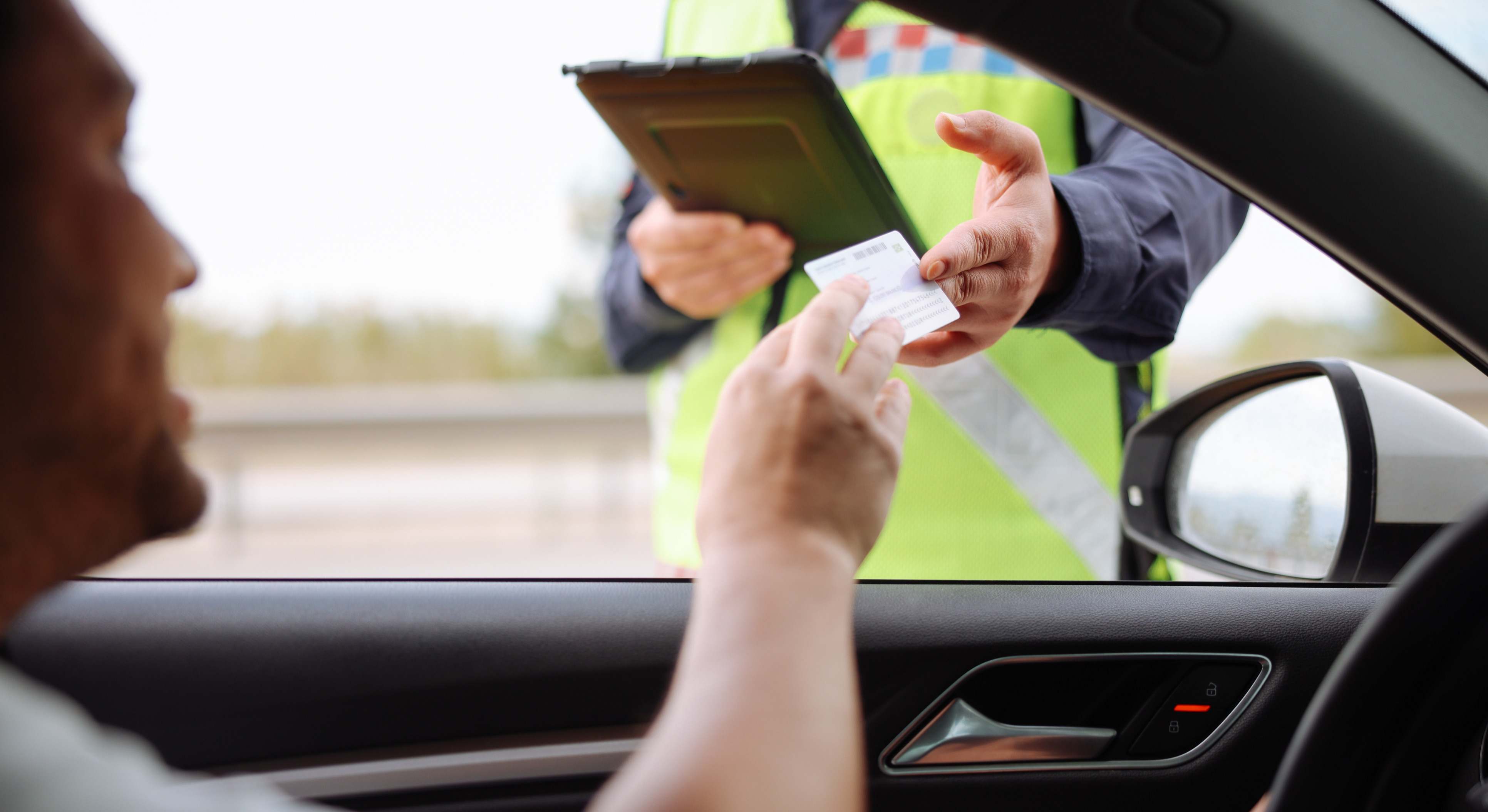 Agente de tráfico solicitando el carnet de conducir a un conductor