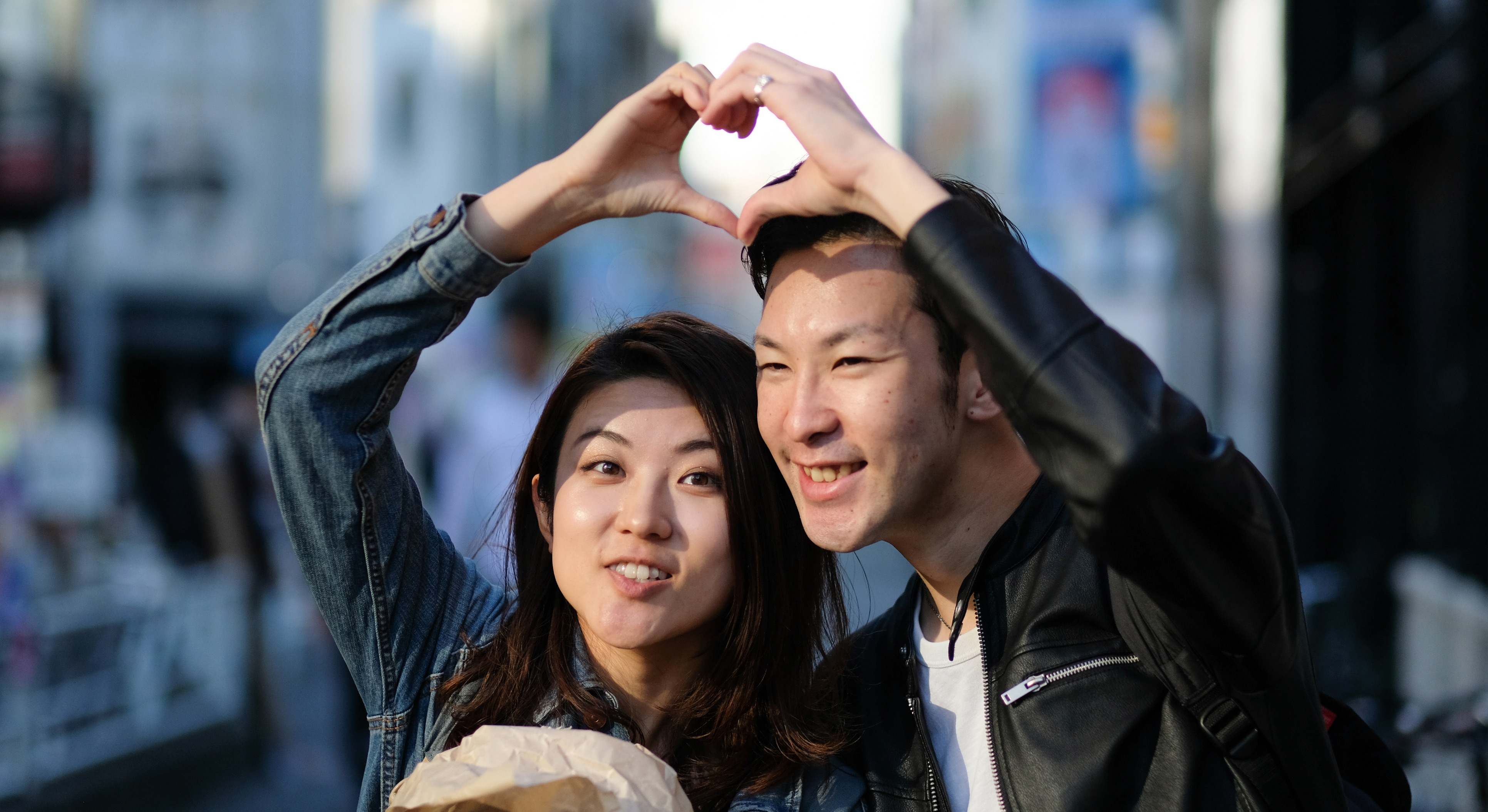 Pareja en Tokio haciendo un corazón con las manos. Foto: iStock