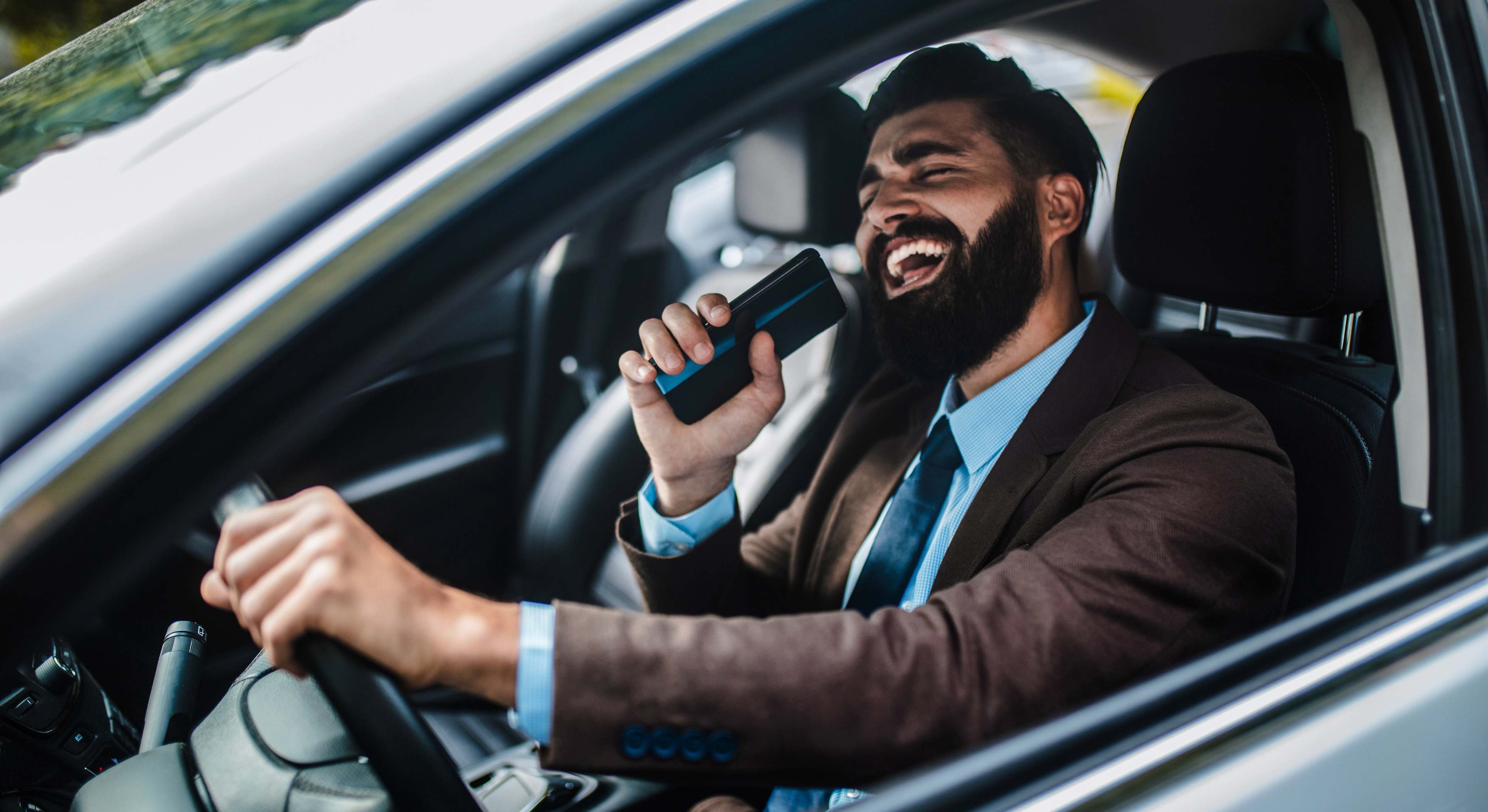 Conductor en el coche cantando
