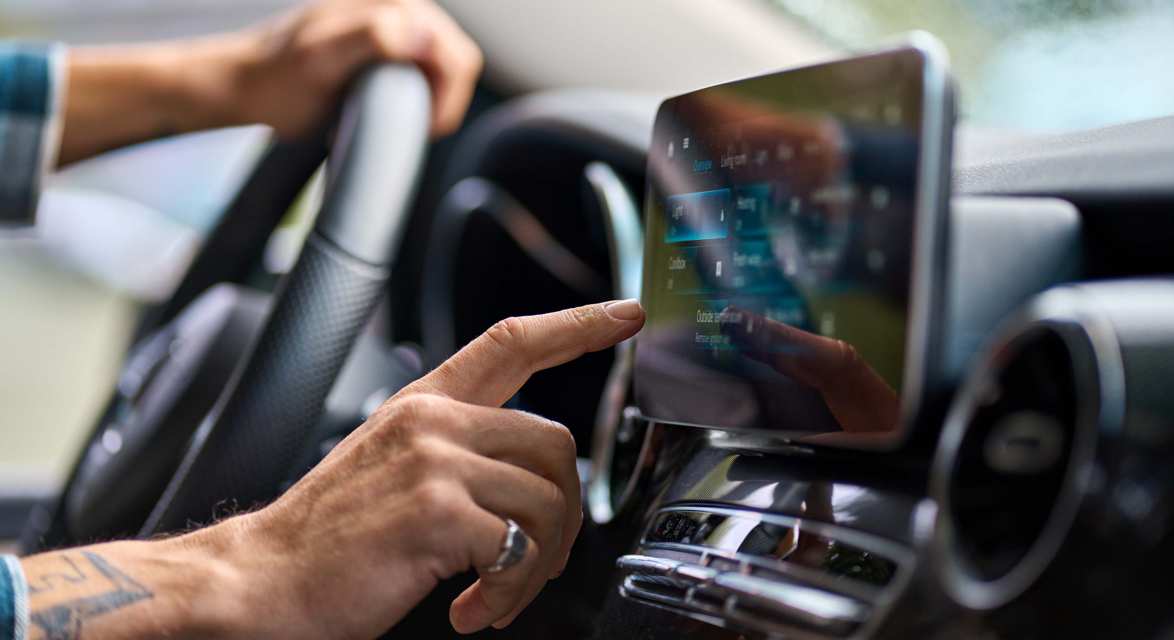 Conductor tocando la pantalla de su coche mientras conduce
