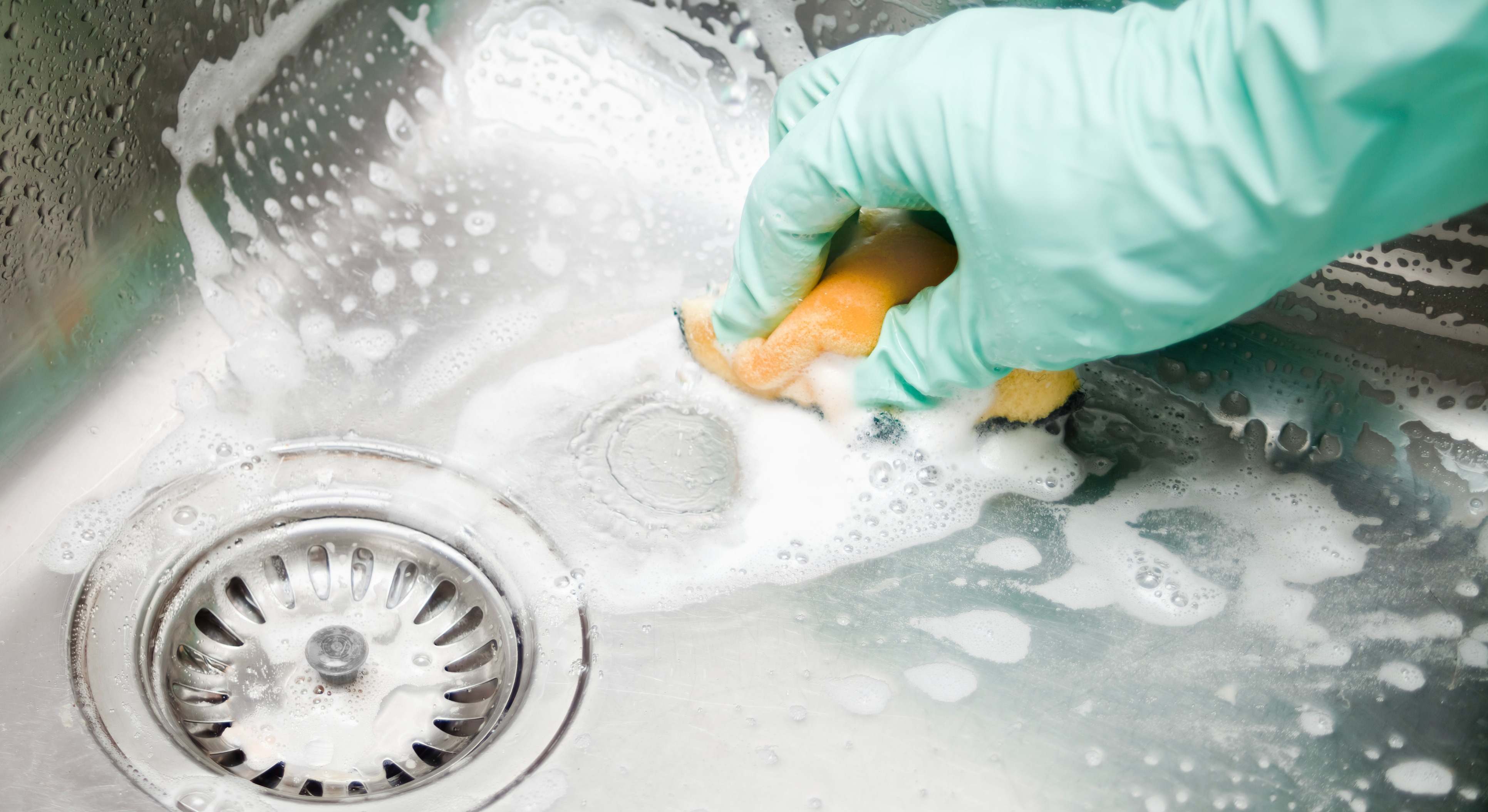 Una persona limpia y desinfecta el fregadero de casa. / Foto: iStock