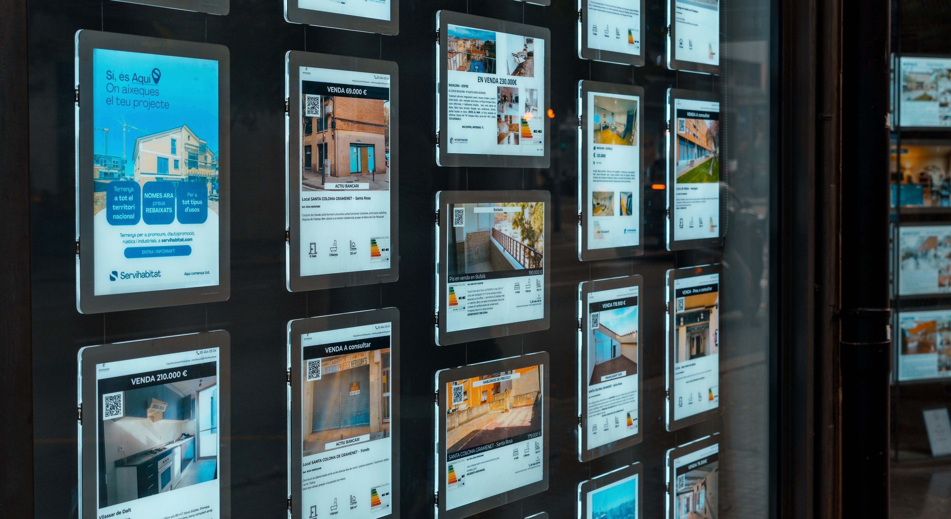 Escaparate de una agencia inmobiliaria con anuncios de pisos en venta o alquiler
