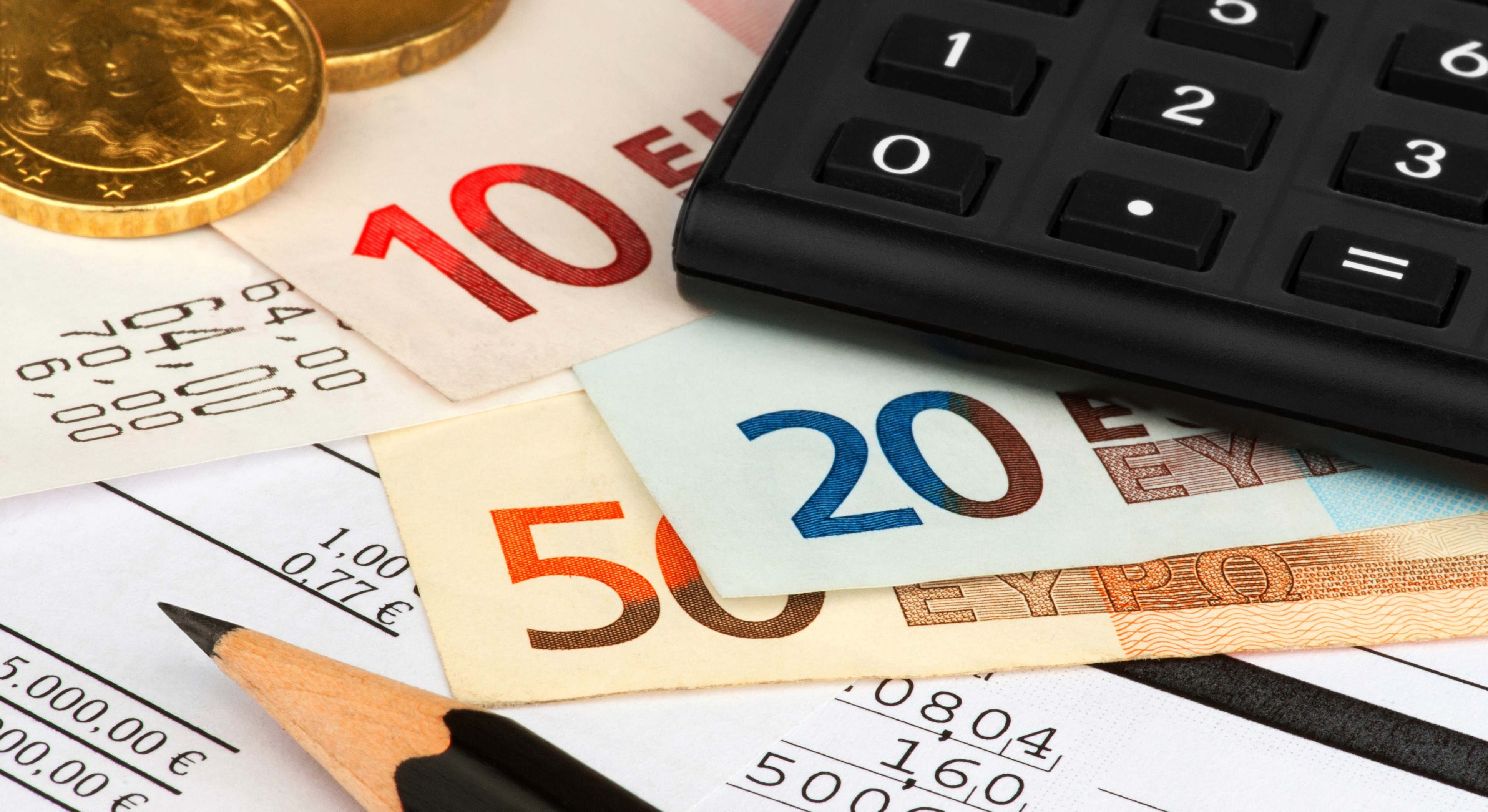 Varios billetes y monedas junto a una calculadora