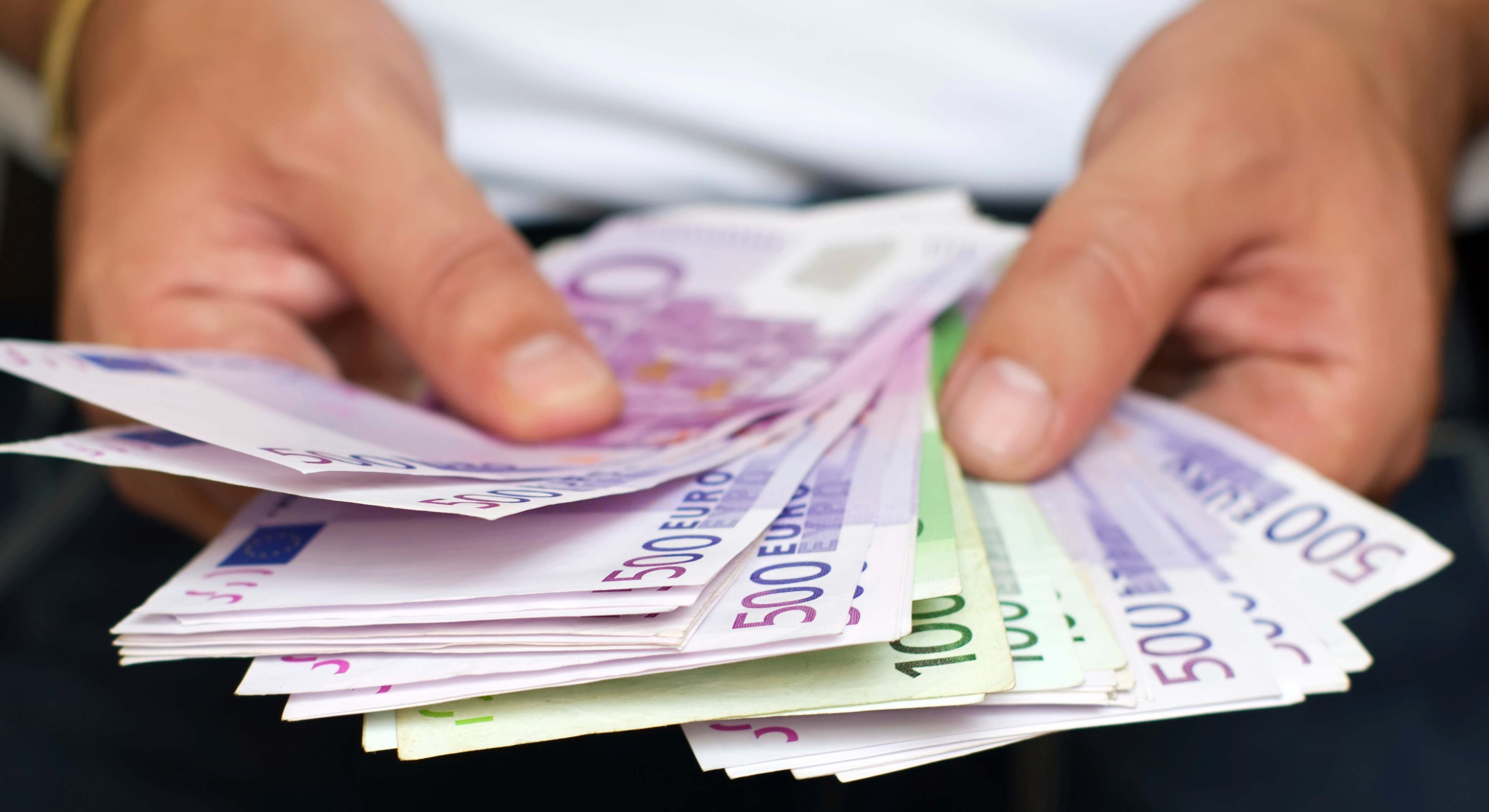 Una persona sostiene varios billetes.