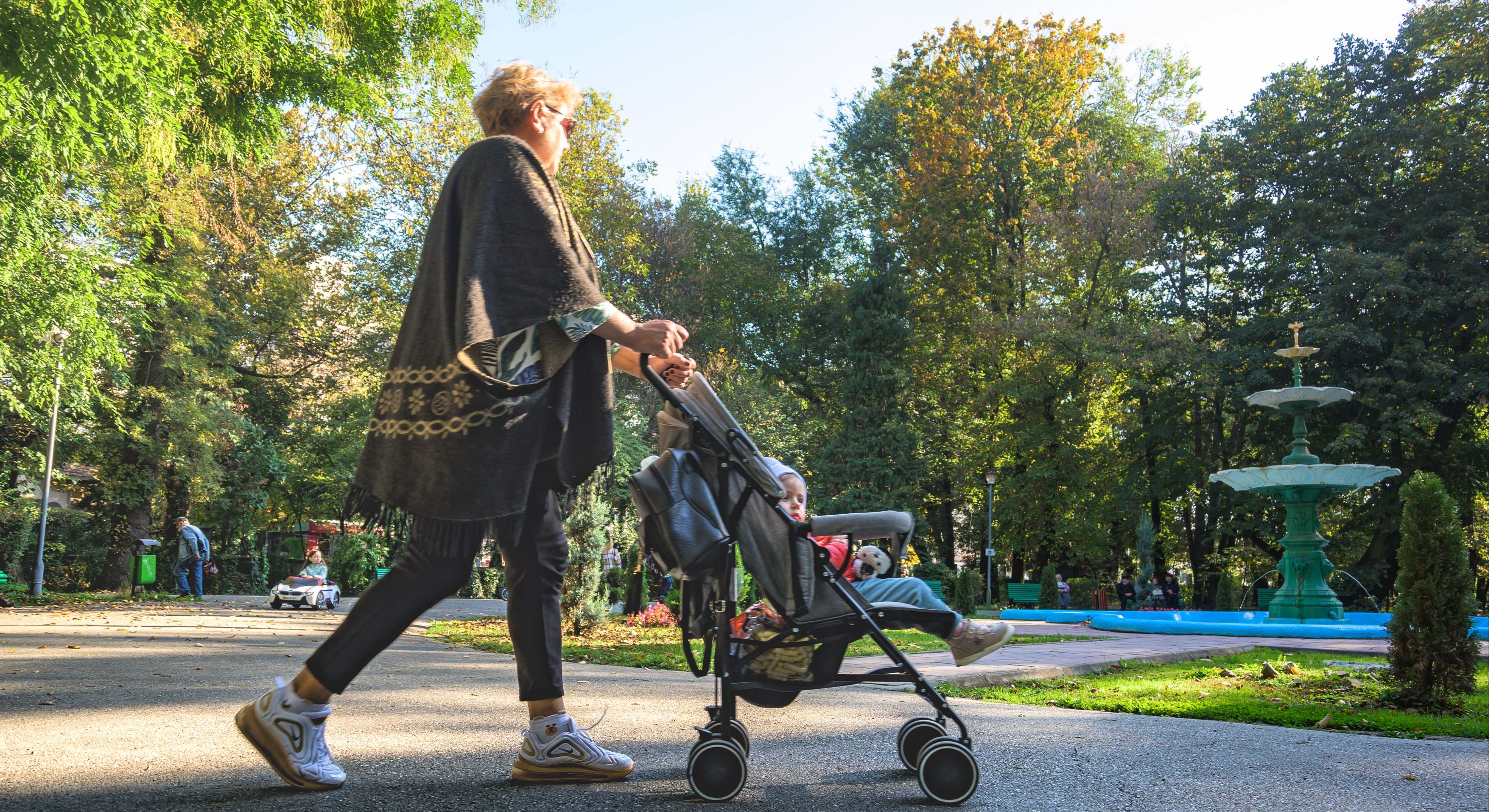 Madre paseando a su hijo en un carro por el parque. Foto: iStock